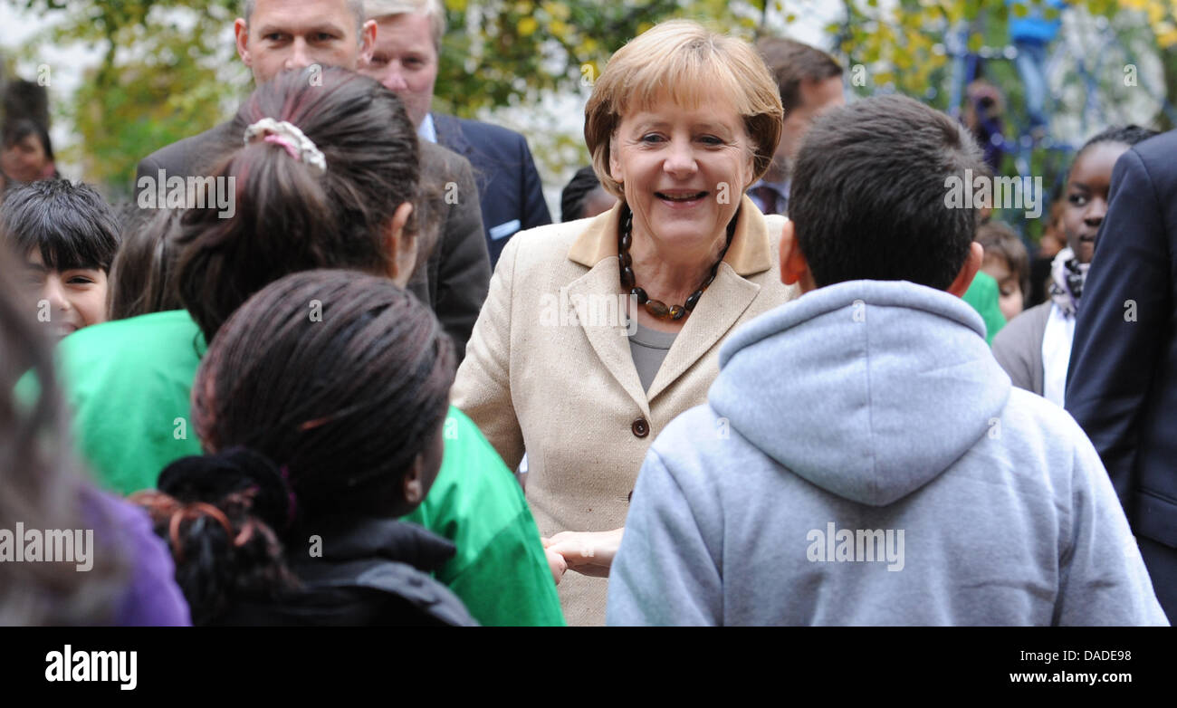 Bundeskanzlerin Angela Merkel wird von Schülern der Erika-Mann-Grundschule im Bezirk Wedding in Berlin, Deutschland, 20. Oktober 2011 begrüßt. Merkel will einen Eindruck von der Situation an einer Schule mit vielen nicht-deutsche Muttersprachler zu gewinnen. Foto: RAINER JENSEN Stockfoto