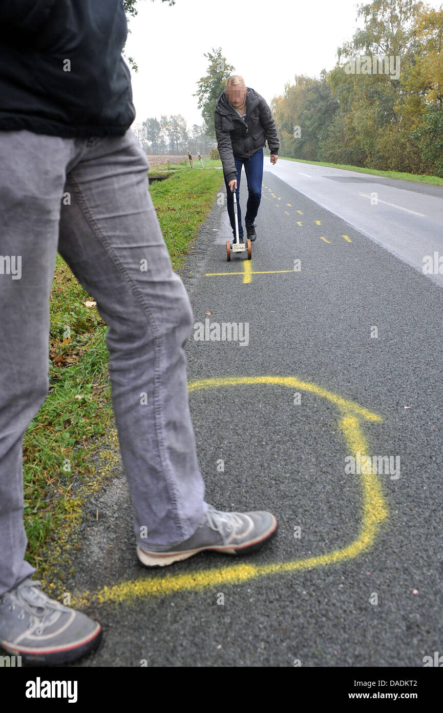 Polizeibeamte untersuchen den Unfallort an der Dueversbrucher Street in der Nähe von Rehden, Deutschland, 29. Oktober 2011. Am Abend des 28. Oktober 2011 ein Auto prallte gegen eine Gruppe von 15 Personen. Zwei Menschen wurden getötet, weitere drei leicht verletzt. Foto: MICHAEL BAHLO Stockfoto