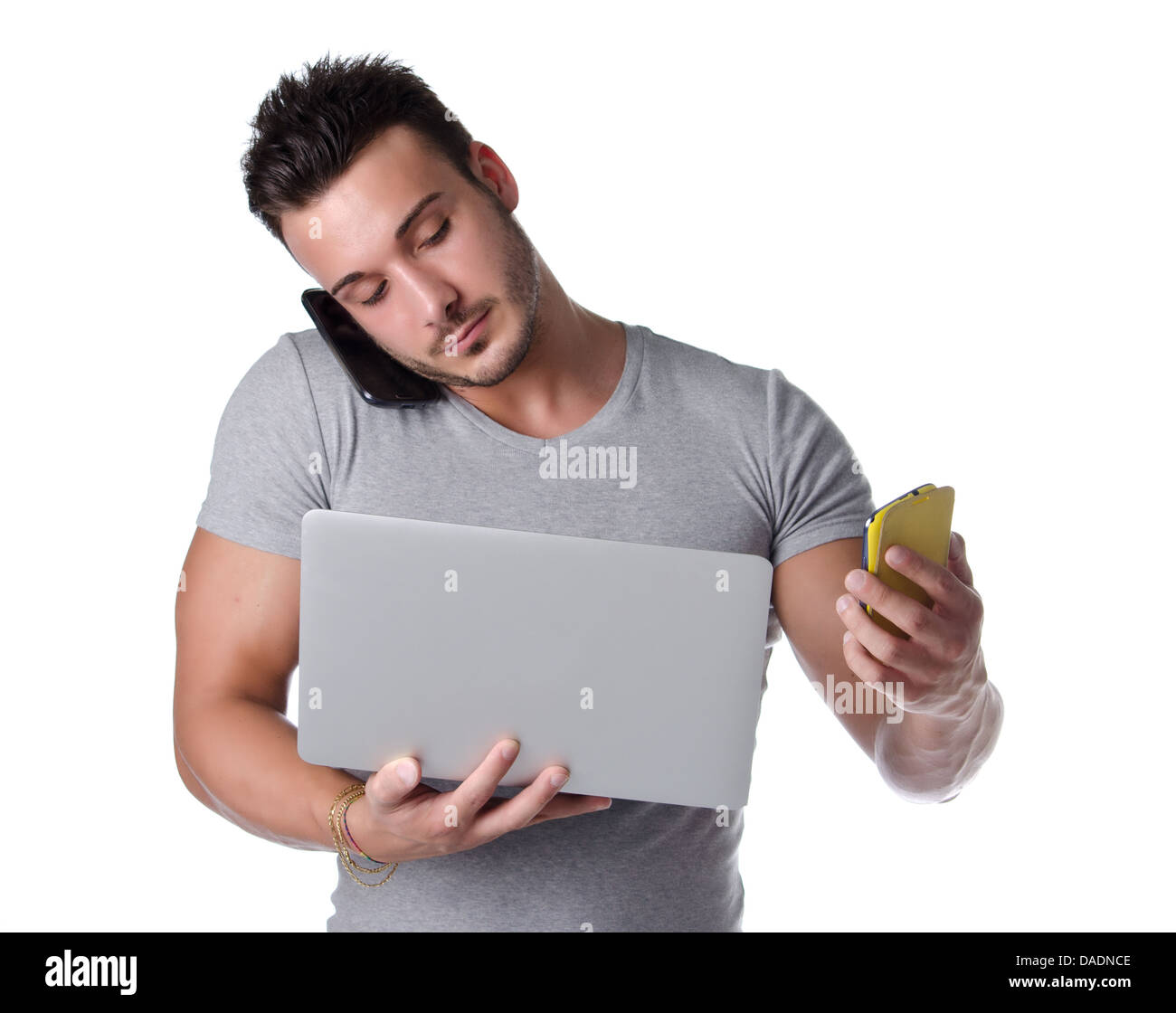 Zu viel Technik. Junger Mann mit zwei Handys und einem Laptop-Computer,  isoliert auf weiss Stockfotografie - Alamy