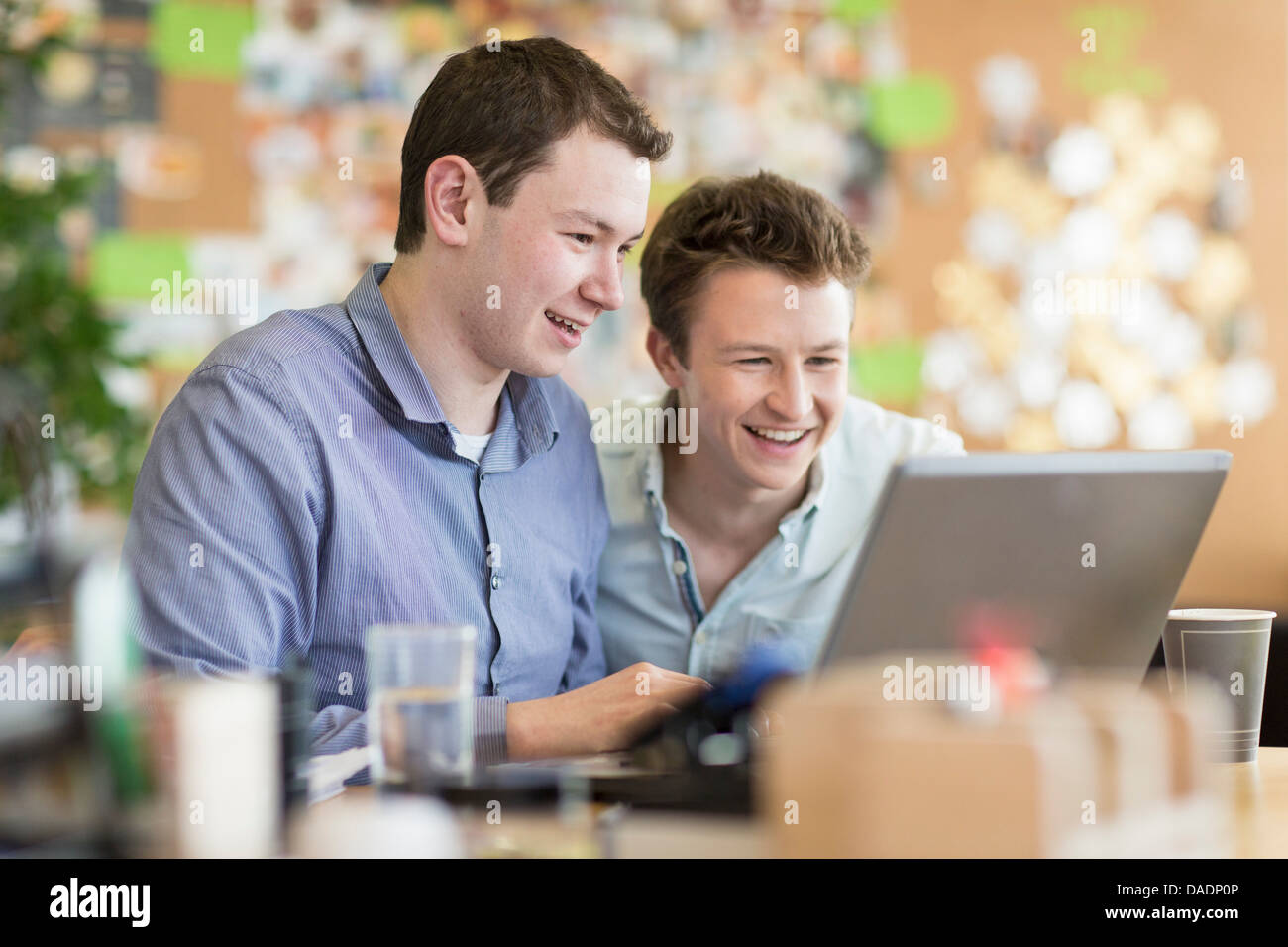 Junge Männer, die Arbeiten am Laptop in Kreativbüro Stockfoto