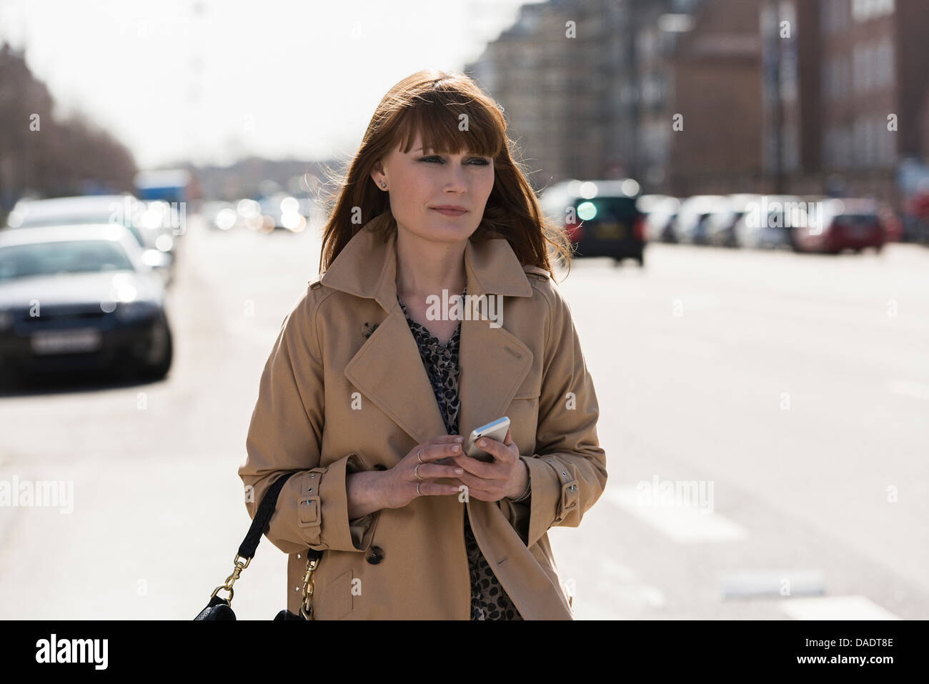 Frau mit Handy auf Straße Stockfoto