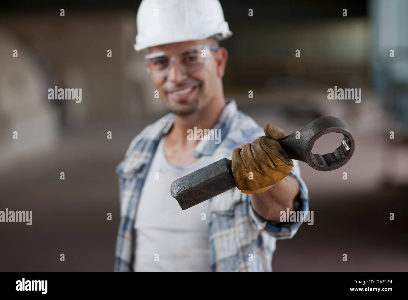 Mitte adult Bauarbeiter tragen Schutzhelm und Holding Schraubenschlüssel, Porträt Stockfoto