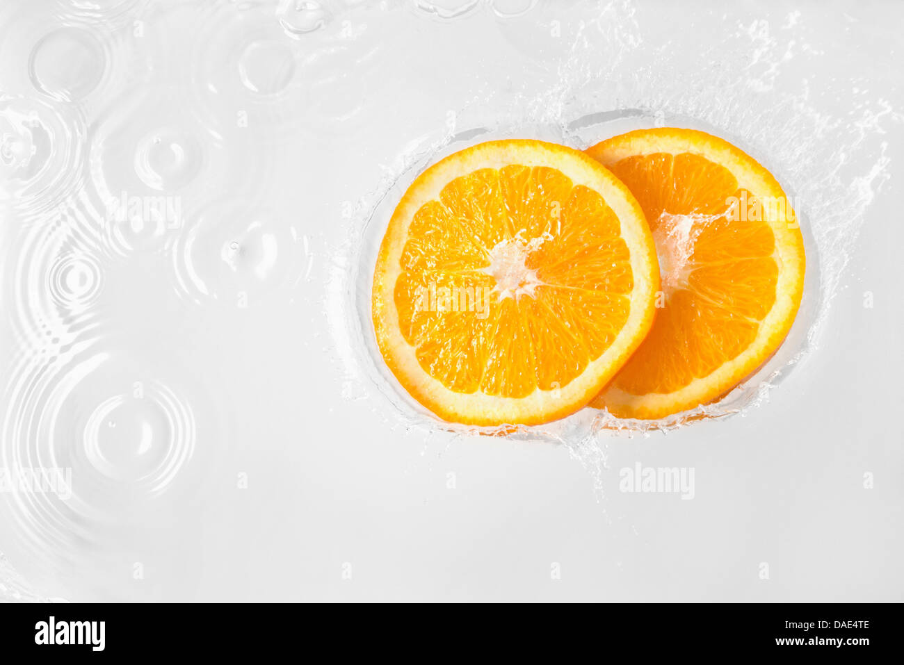 Zwei Scheiben Orange schwebende in Flüssigkeit Stockfoto