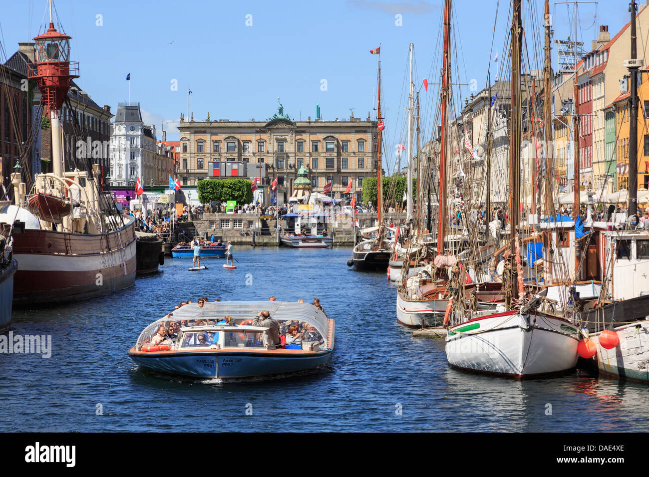 Touristen auf Rundfahrt Boot mit alten Holzboote vertäut im Hafen von Nyhavn, Kopenhagen, Seeland, Dänemark, Scandinavia Stockfoto