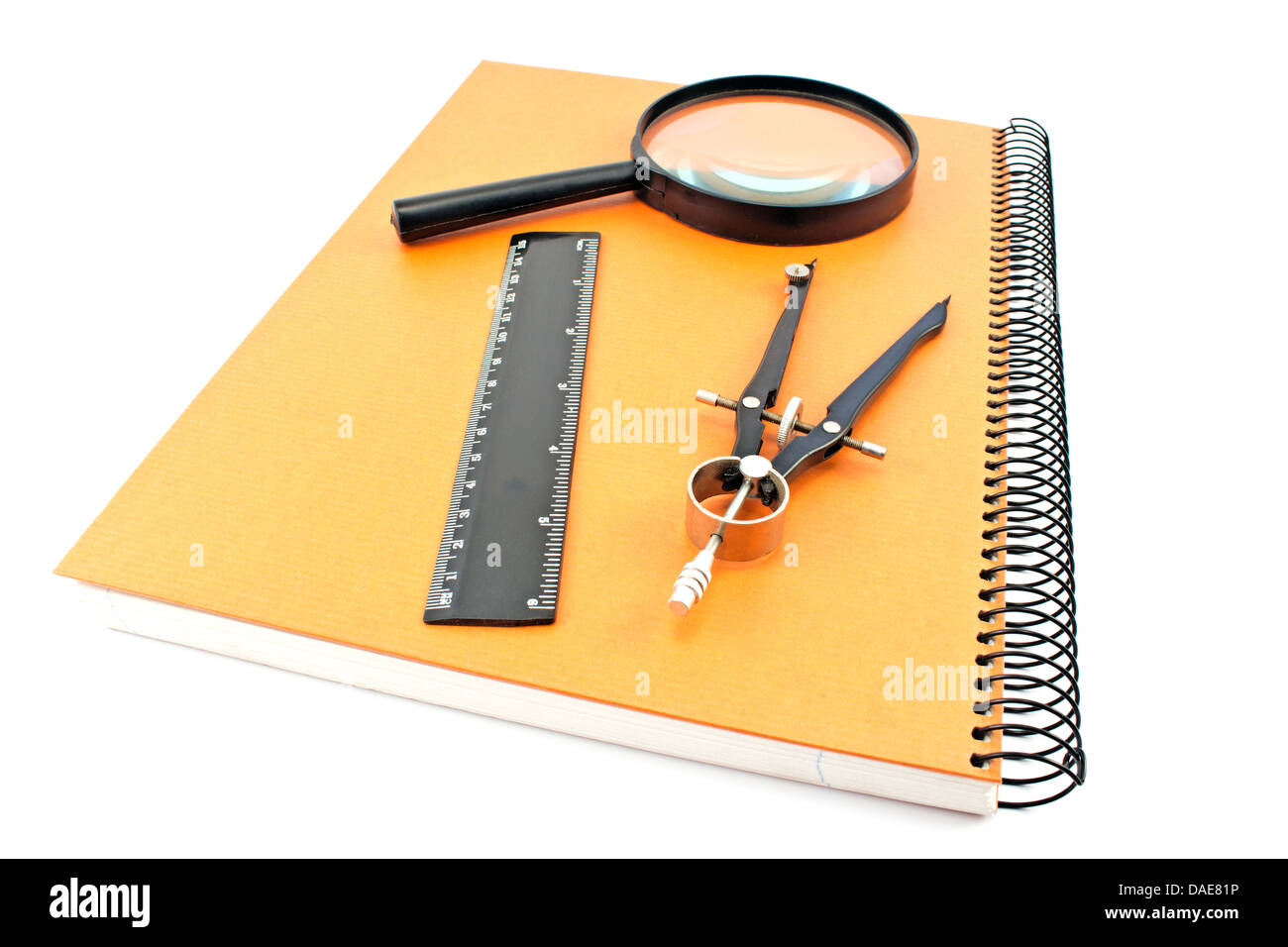 Notebook mit Zeichnung, Zirkel, Lineal und Lupe isoliert auf weiss Stockfoto