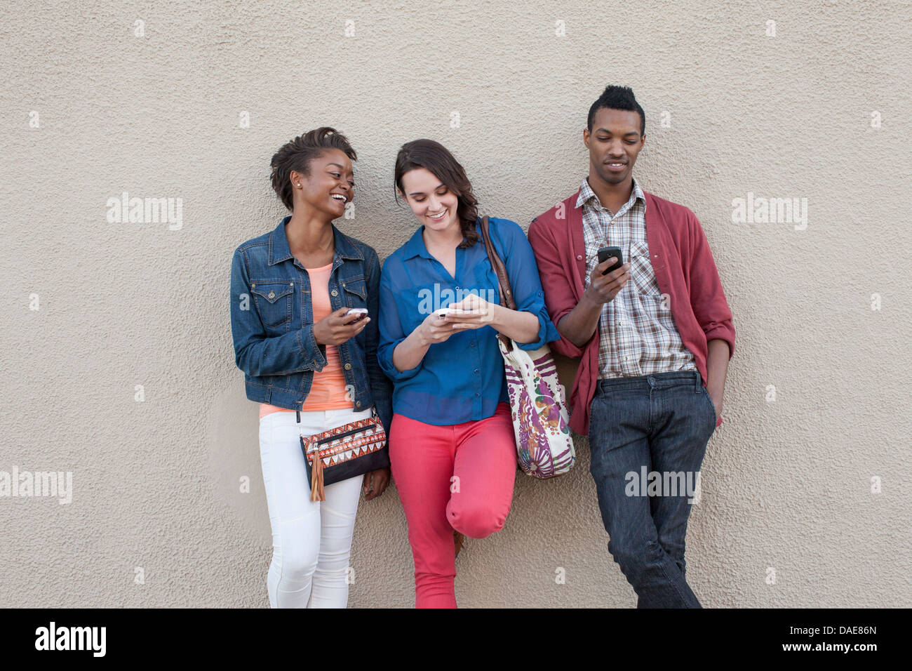 Drei Freunde mit Handys Stockfoto