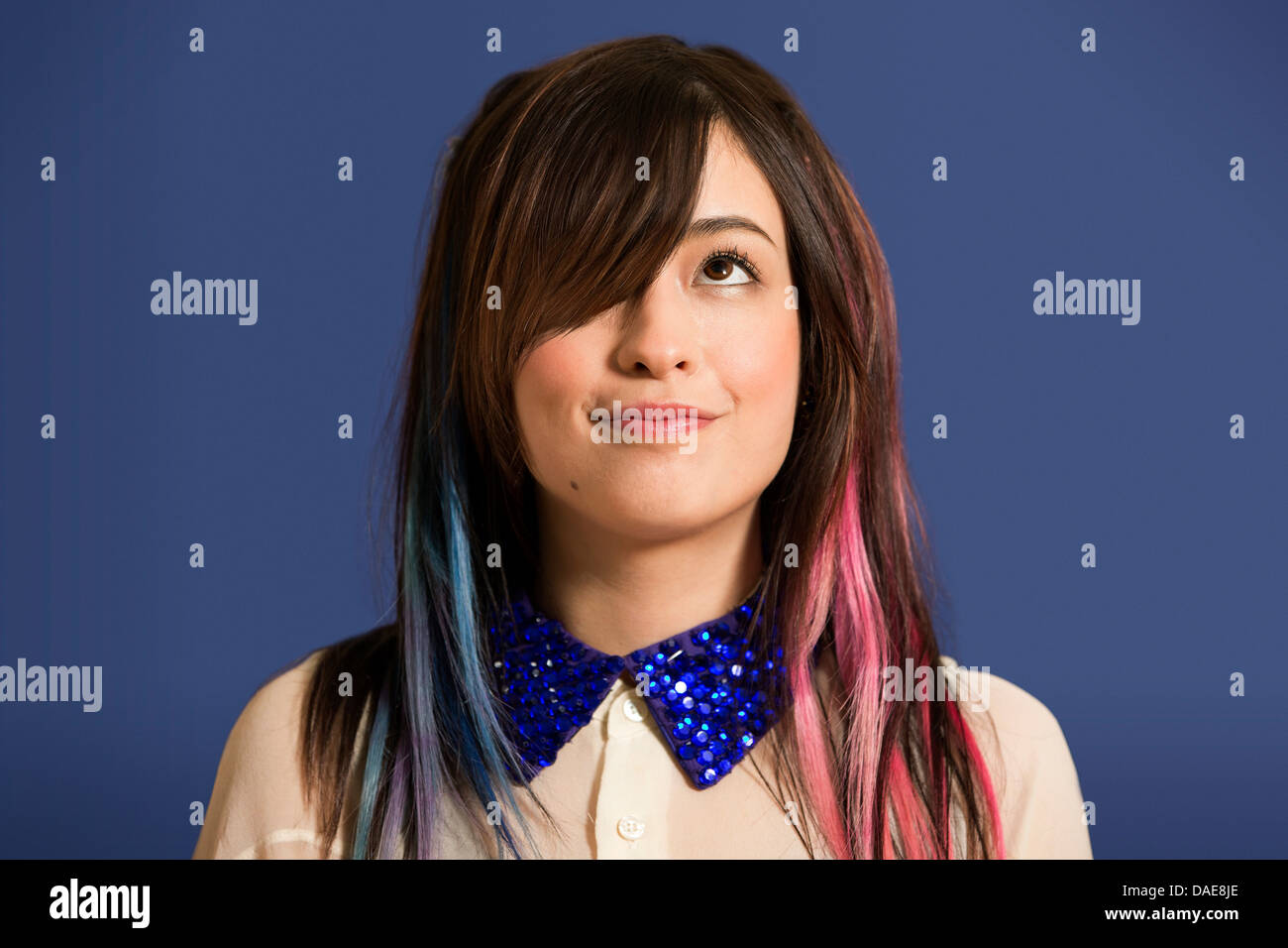 Porträt der jungen Frau mit gefärbten Haaren und blauen Pailletten Kragen Stockfoto