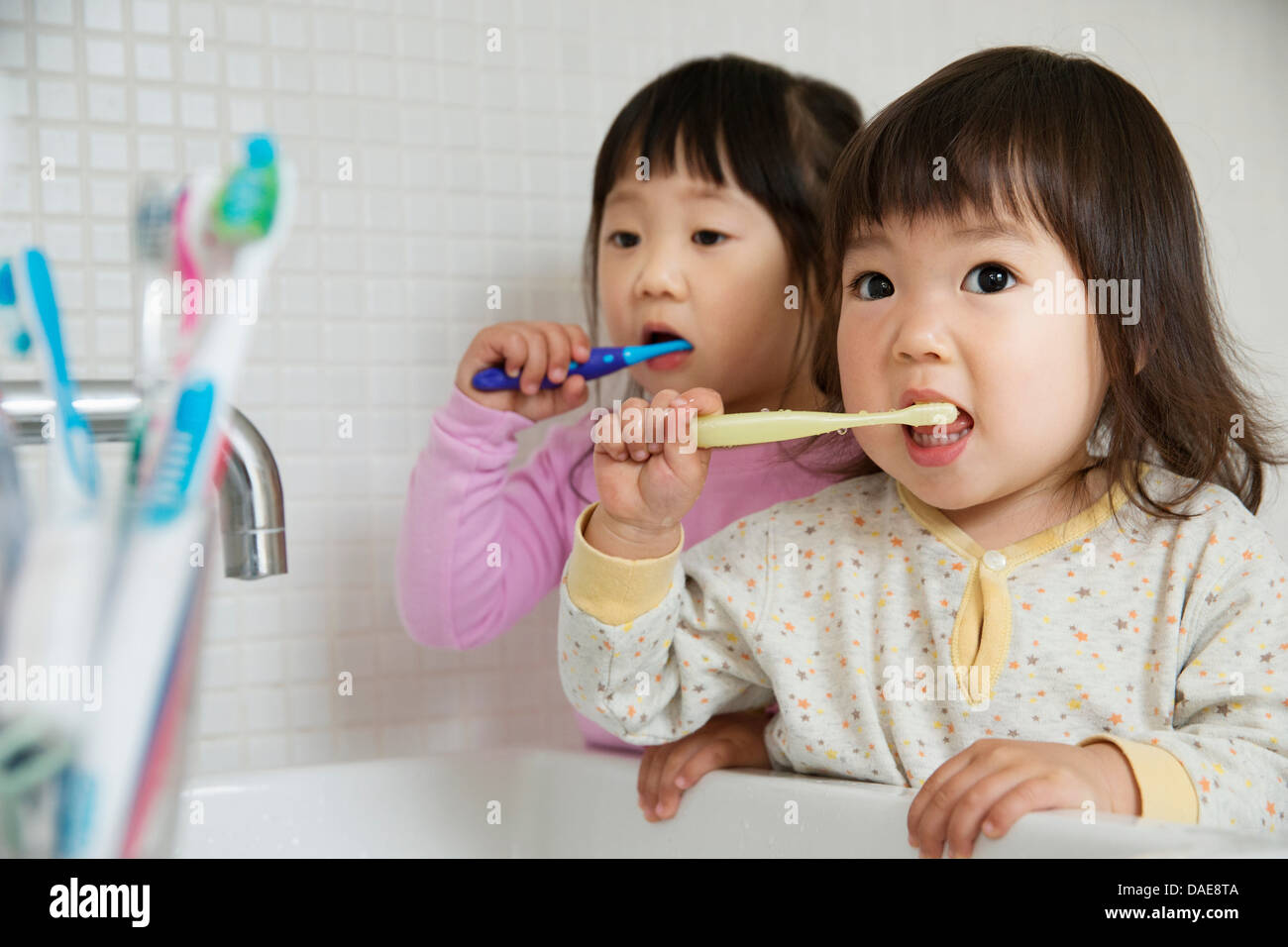 Zwei Mädchen Kleinkinder Zähneputzen im Badezimmer Waschbecken Stockfoto