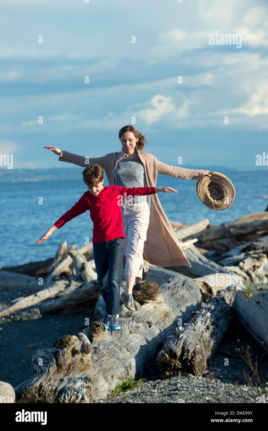 Mutter und Sohn Baumstamm an Küste entlang Stockfoto