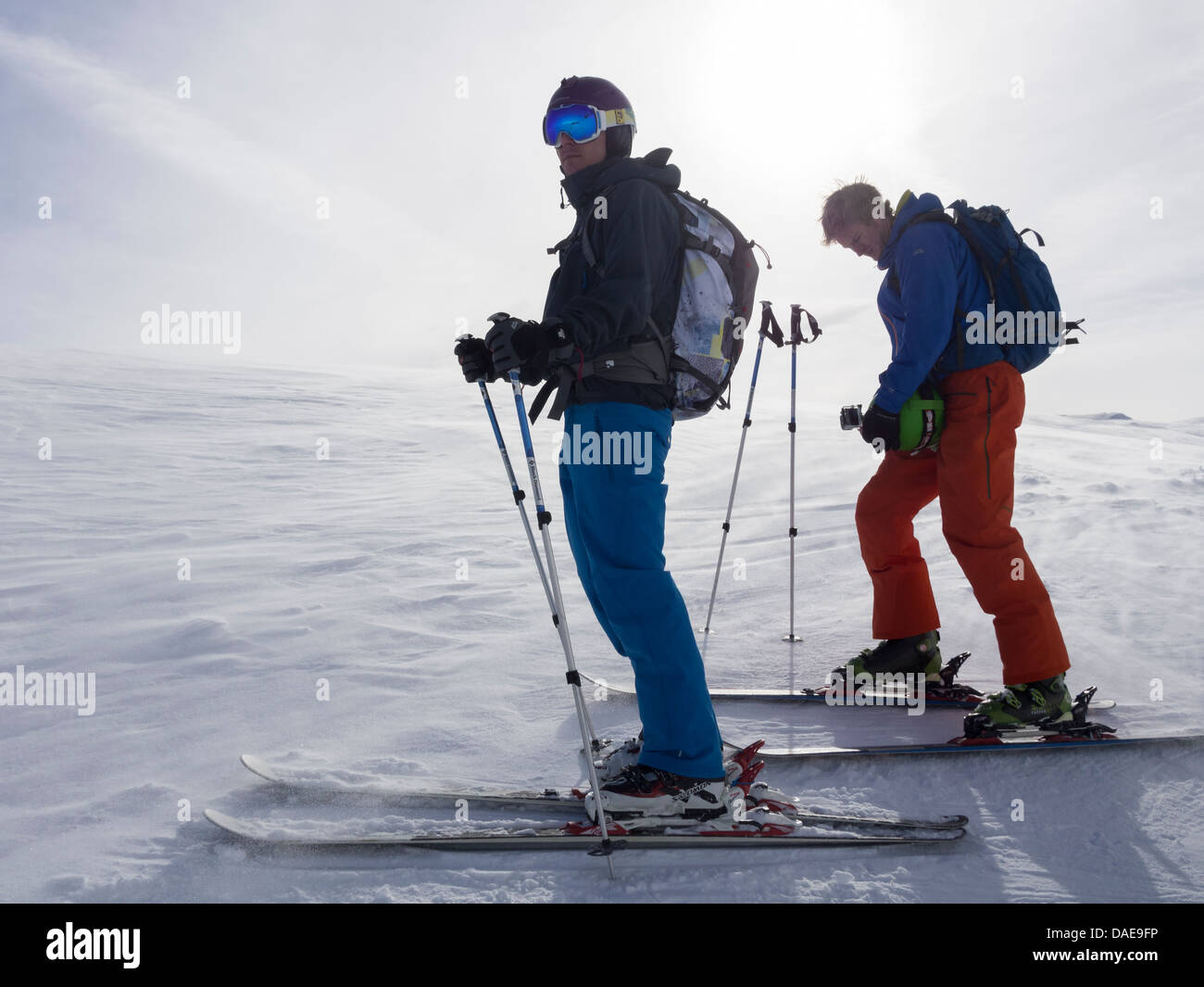 Zwei männliche Skifahrer auf Ski Urlaub Hintergrundbeleuchtung gegen Sonne auf schneebedeckte Pisten in den französischen Alpen in der Nähe von Samoens, Rhône-Alpes, Frankreich, Europa Stockfoto