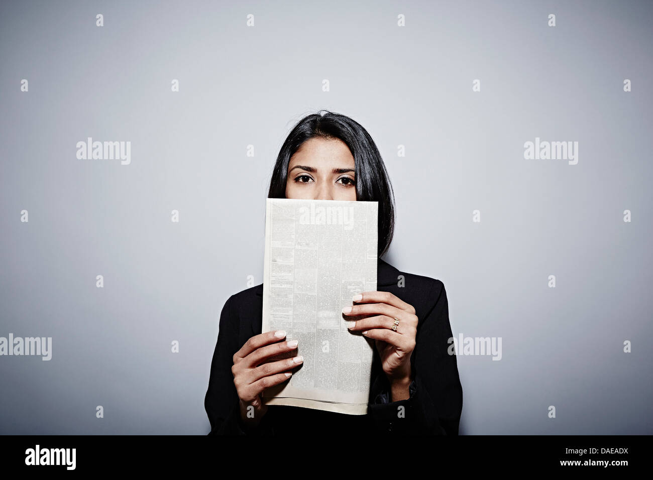 Studio-Porträt der Geschäftsfrau Zeitung hochhalten Stockfoto