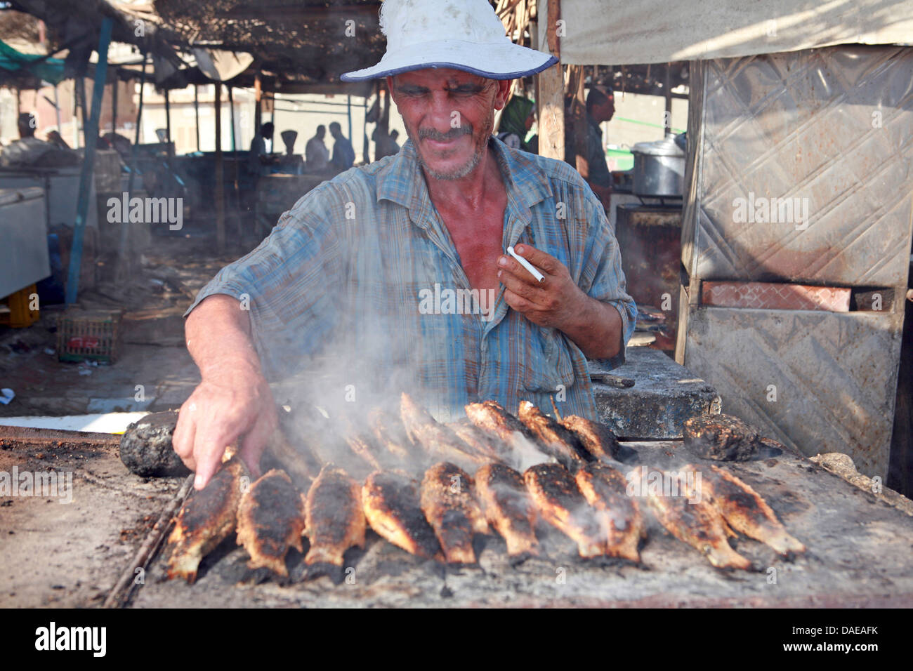 ältere Mann grillenden Fische am Fisch Markt, Ägypten, Hurghada Stockfoto