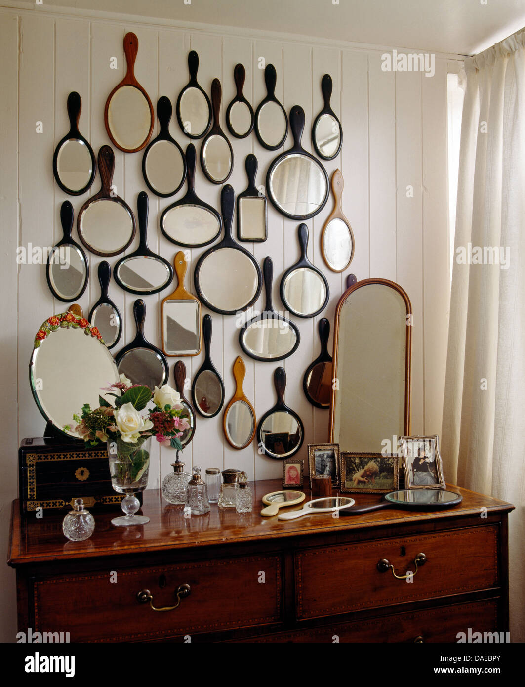 Sammlung von antiken Hand Spiegel über Kommode mit schmalen Spiegel und Sammlung von Vintage Flakons Stockfoto