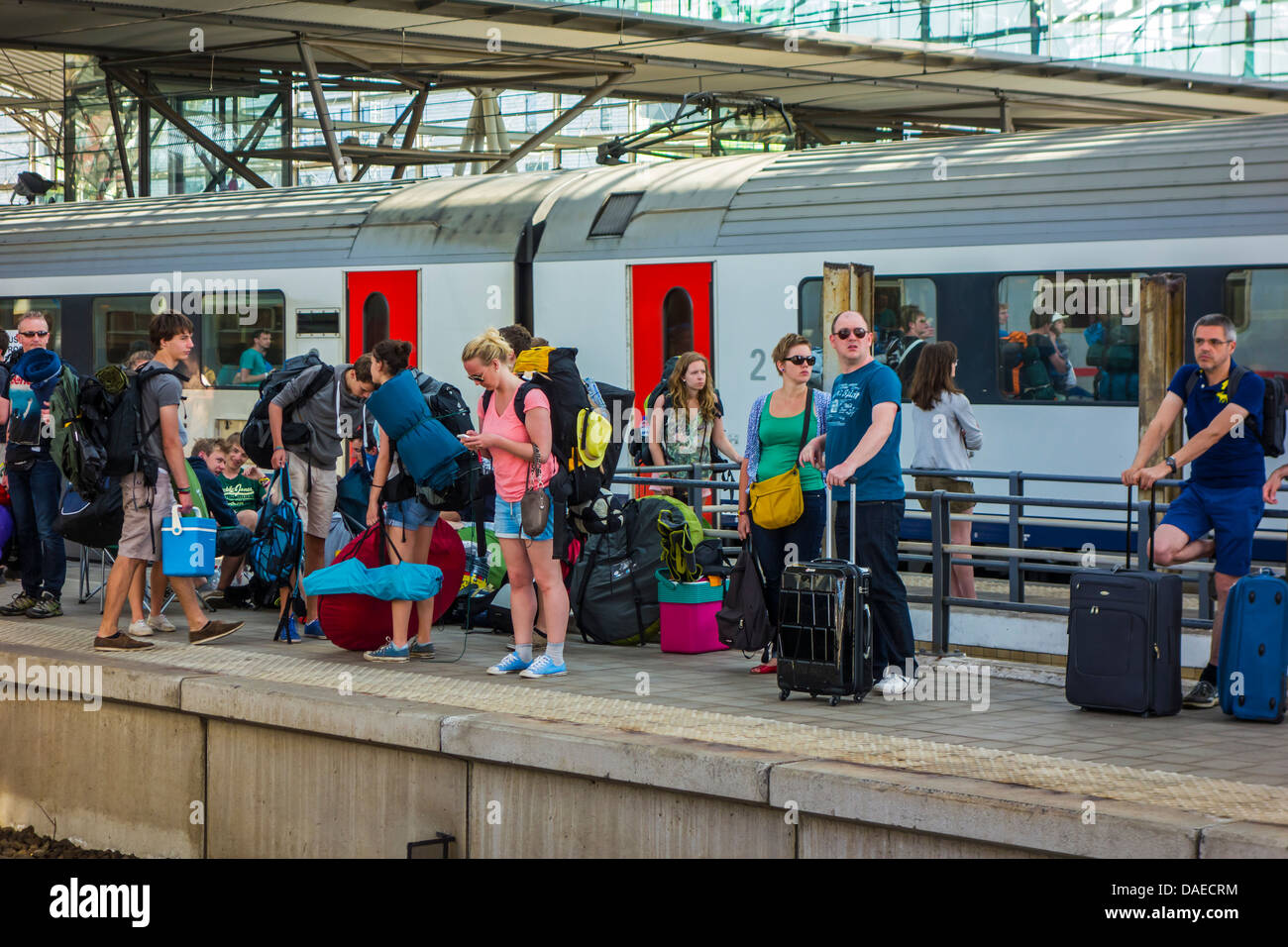 Touristen mit Koffern und Rucksacktouristen im Urlaub warten auf Plattform für Zug am Bahnhof in den Sommerferien Stockfoto