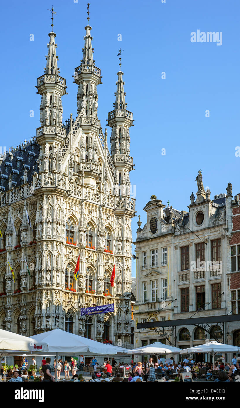 Touristen an Straßencafés vor dem gotischen Rathaus auf dem Grote Markt / Main Market square, Leuven / Louvain, Belgien Stockfoto