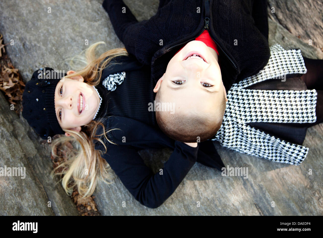Lächelnd, jungen und Mädchen, die Verlegung auf Stein Ledge, High Angle View, Porträt Stockfoto