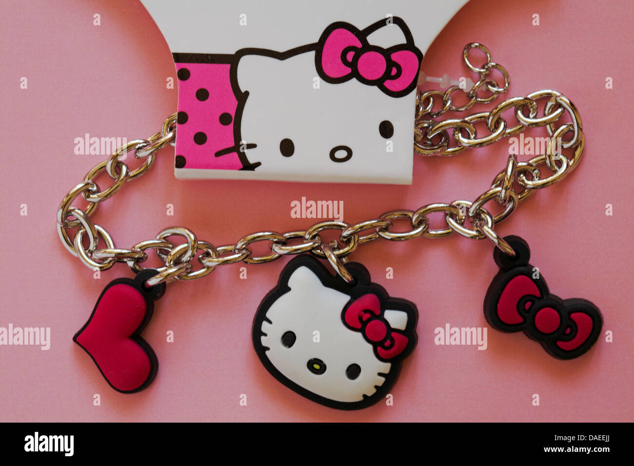 Hallo Kitty Charm Armband mit rotem Herz und Bogen Set auf rosa Hintergrund Stockfoto