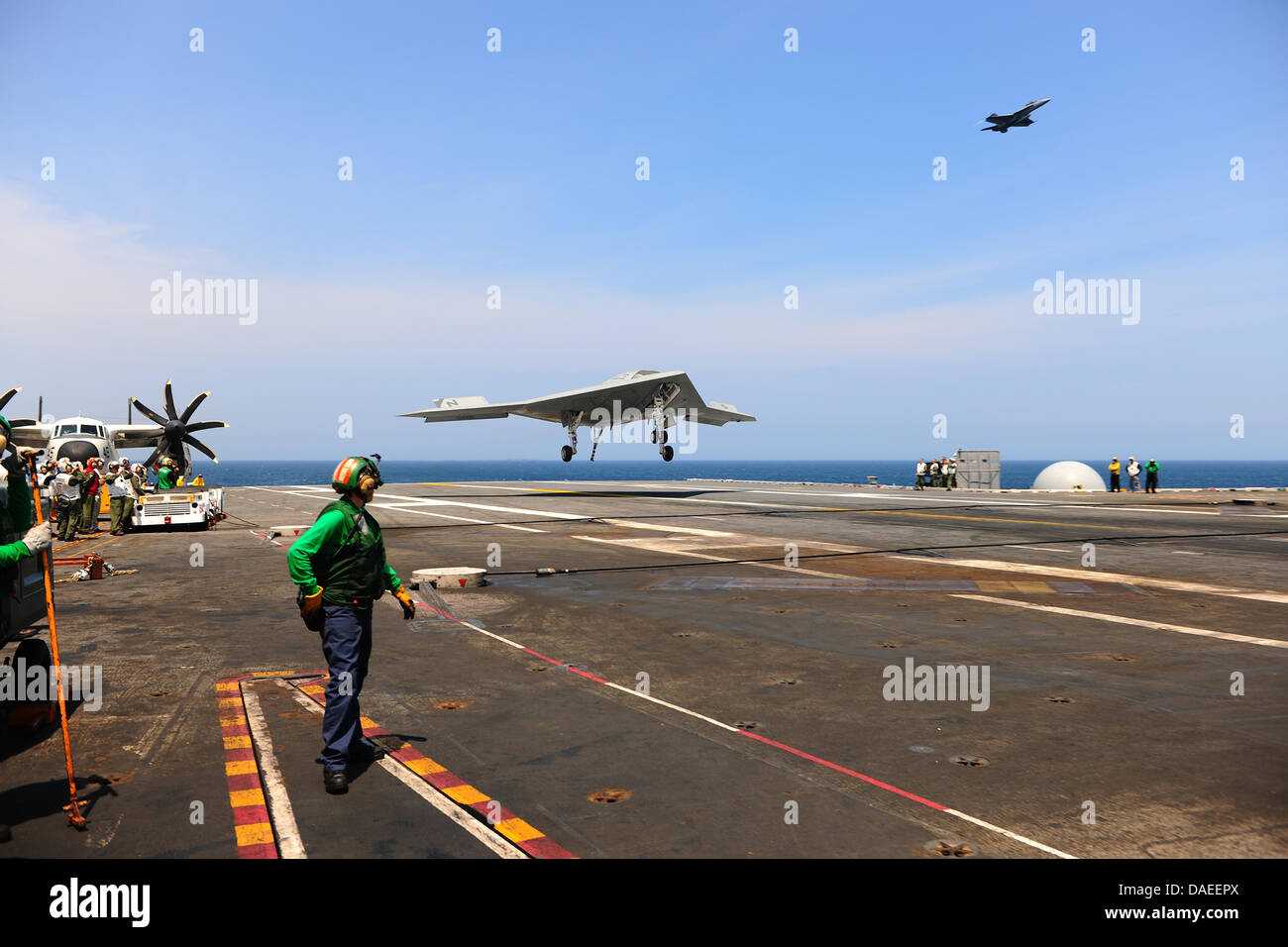 Eine US-Marine X-47 b unmanned combat Air Systems Drohne macht einen verhafteten landen auf dem Flugdeck des Flugzeugträgers USS George H.W. Bush 10. Juli 2013 in Betrieb im Atlantischen Ozean. Die Landung war das erste Mal, das eine unbemannte Flugzeuge eine verhaftete Landung auf hoher See abgeschlossen. Stockfoto