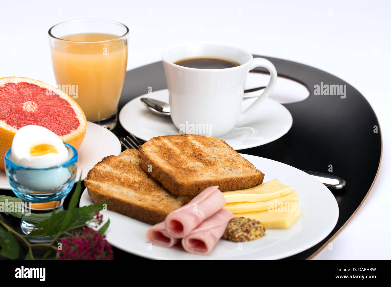 Frühstück mit Toast, Schinken, Käse, Ei, Grapefruit, Saft und Kaffee. Stockfoto