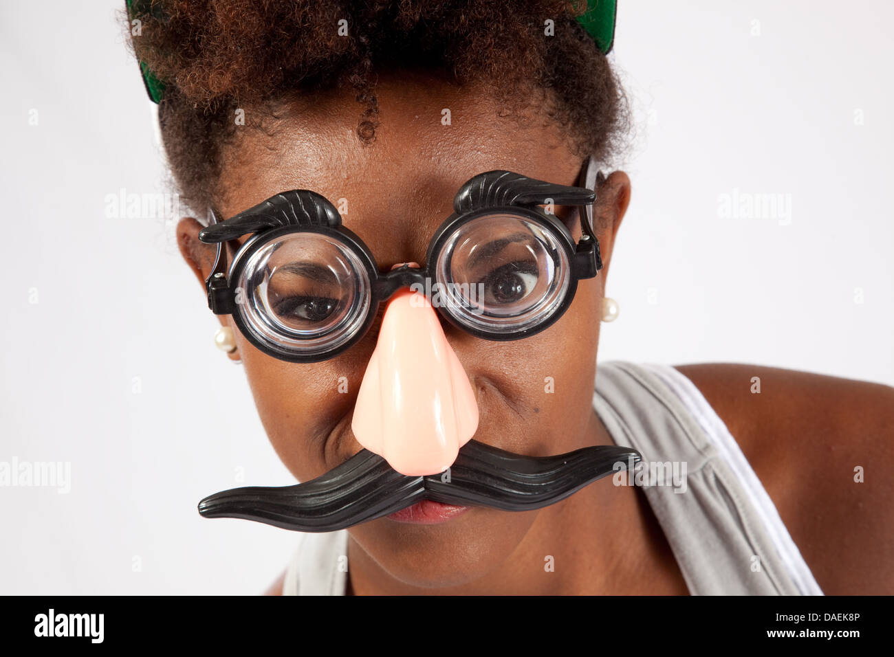 Ziemlich schwarz Frau fake Brille mit Nase und Gesicht Haar, Lächeln in die  Kamera mit verspielten, Glee Stockfotografie - Alamy