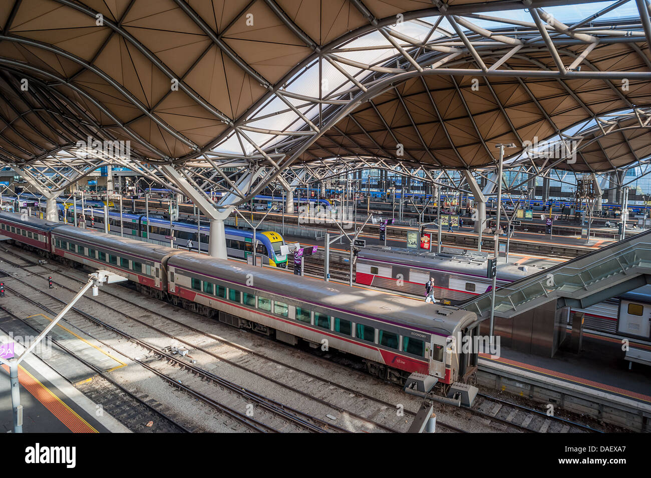 Leute warten auf einen Zug auf einer Plattform in einem höhlenartigen Bahnhof. Stockfoto
