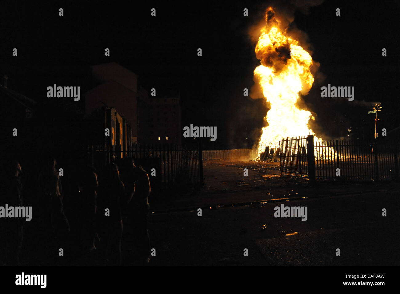 Belfast, Nordirland. 11. Juli 2013. Am 11. Juli werden standhaft protestantischen Gebieten "Elfte Nacht" Freudenfeuer angezündet. Viele sind massive Konstruktionen aus Holz Paletten, alte Sofas und Gummireifen, garniert mit irischen Fahnen oder Bildnisse von pro-Nationalist zahlen. Lagerfeuer Architekten Schlacht es sehen, wer der größte aufbauen kann und Verschiebungen der junge Wächter sicherzustellen, dass die rivalisierende Bauherren nicht brennbarer Beute stehlen. Um Mitternacht die Freudenfeuer angezündet werden, und diese wütenden Infernos lodernden quer durch die Stadt zu sehen. Im Bild: Sandy Row Lagerfeuer. Bildnachweis: Andrew Chittock/Alamy Live-Nachrichten Stockfoto