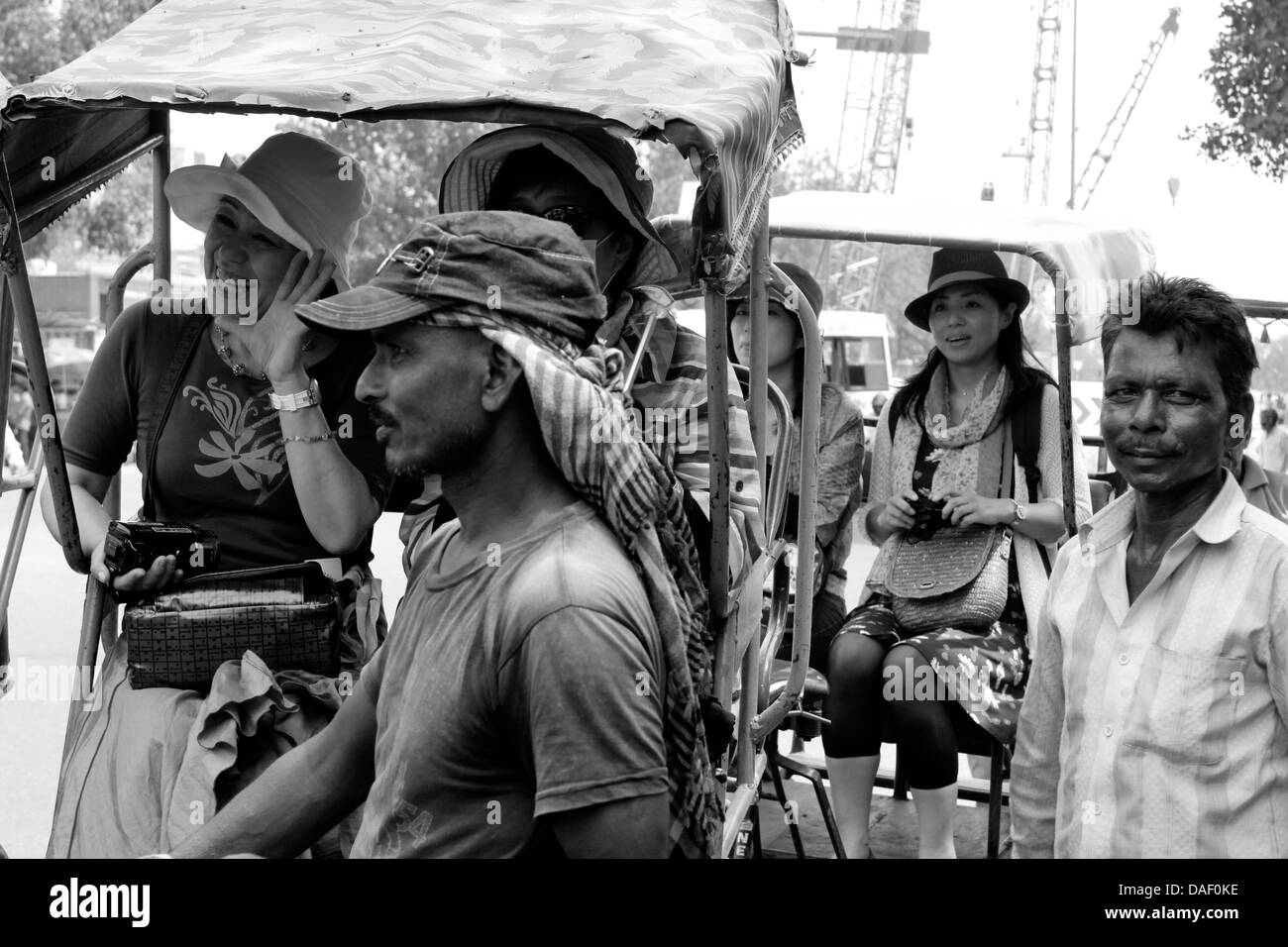 Ein Zyklus-Rikscha-Fahrer mit ausländischen Touristen in New Delhi, Indien Stockfoto