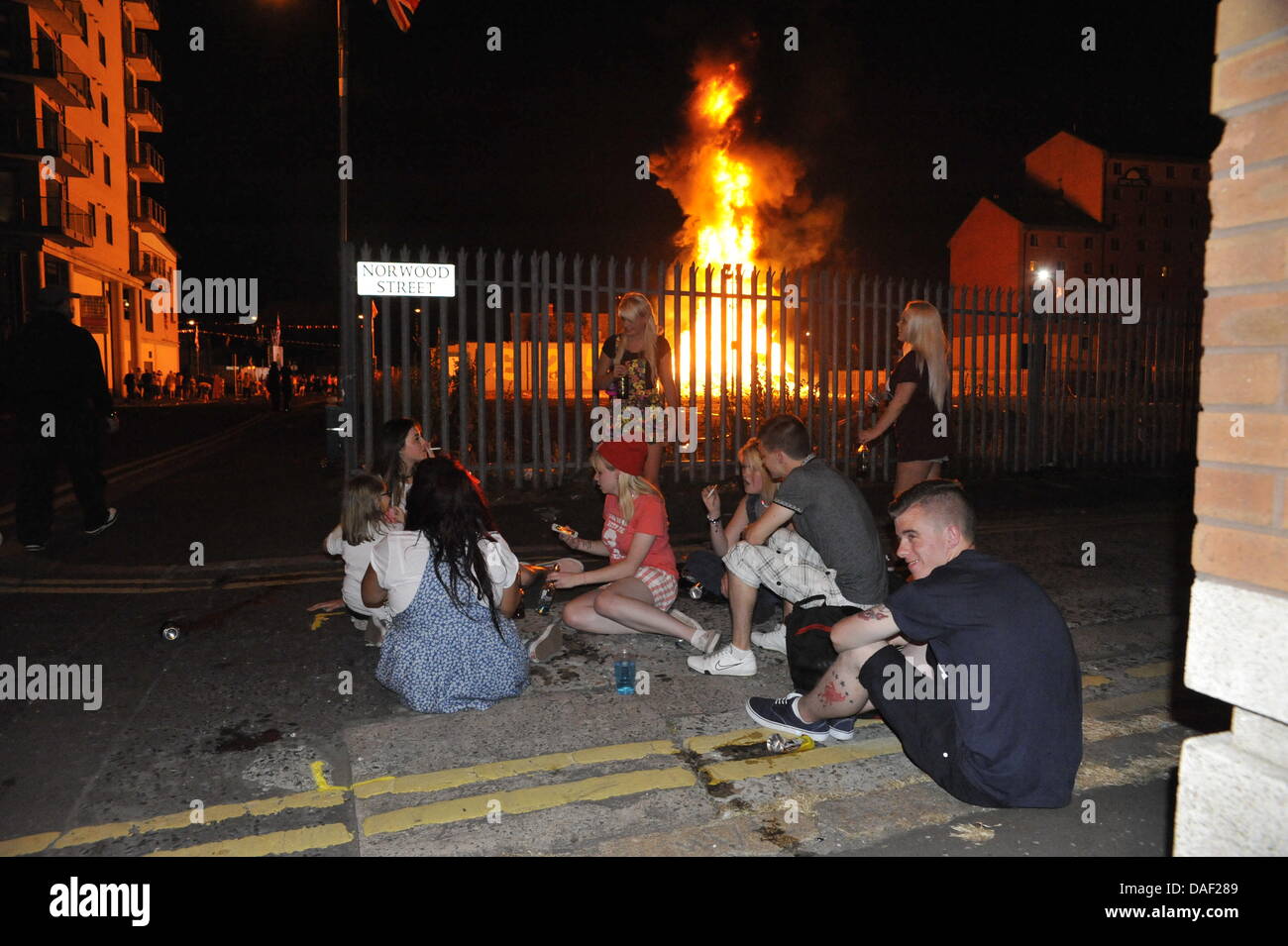 Belfast, Nordirland. 11. Juli 2013. Am 11. Juli werden standhaft protestantischen Gebieten "Elfte Nacht" Freudenfeuer angezündet. Viele sind massive Konstruktionen aus Holz Paletten, alte Sofas und Gummireifen, garniert mit irischen Fahnen oder Bildnisse von pro-Nationalist zahlen. Lagerfeuer Architekten Schlacht es sehen, wer der größte aufbauen kann und Verschiebungen der junge Wächter sicherzustellen, dass die rivalisierende Bauherren nicht brennbarer Beute stehlen. Um Mitternacht die Freudenfeuer angezündet werden, und diese wütenden Infernos lodernden quer durch die Stadt zu sehen. Im Bild: Sandy Row Lagerfeuer. Bildnachweis: Andrew Chittock/Alamy Live-Nachrichten Stockfoto