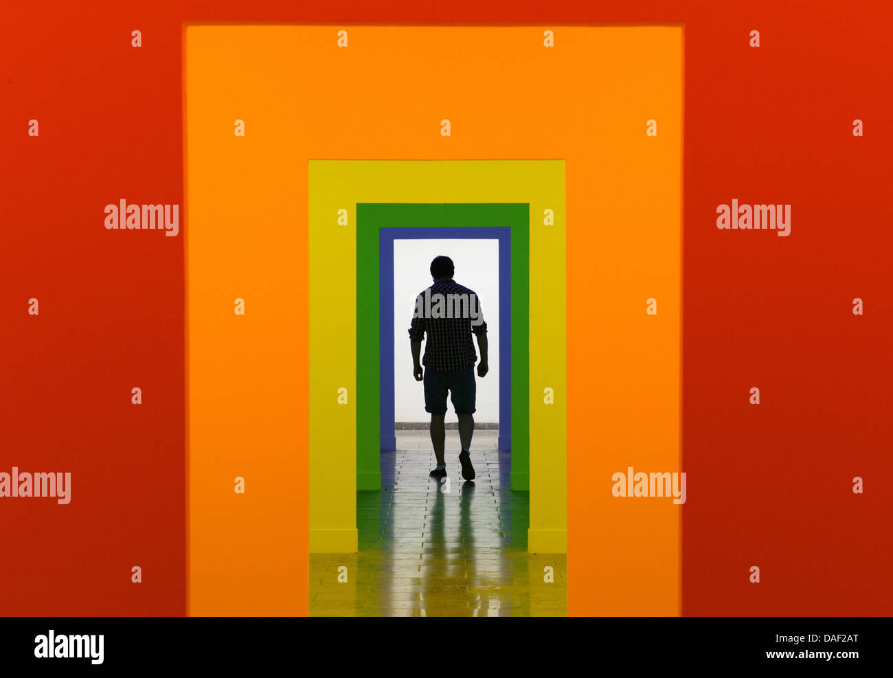 Karlsruhe, Deutschland. 11. Juli 2013. Ein Besucher der Karlsruher Akademie der bildenden Künste geht durch ein Raum-Licht-Installation in Karlsruhe, Deutschland, 11. Juli 2013. Die Installation wurde von der Klasse von Prof. Tatjana Doll erstellt und ist Teil der aktuellen Sommerausstellung bis 14. Juli 2013 weiter. Foto: Uli Deck/Dpa/Alamy Live News Stockfoto