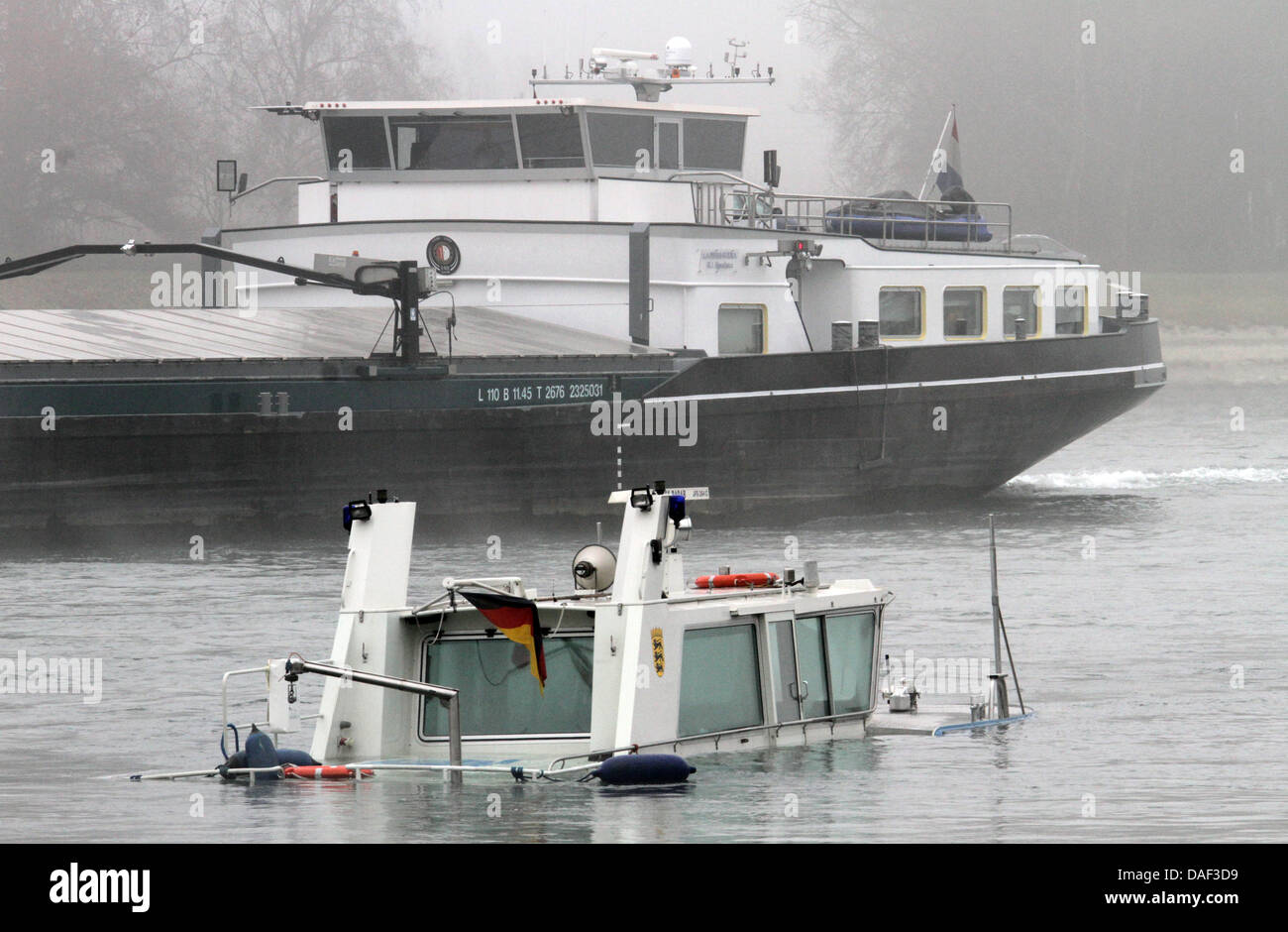 Ein Polizei-Boot liegt im Rhein versenkt in der Nähe von Karlsruhe, Deutschland, 29. November 2011. Das Wasser-Polizei-Patrouillenboot kollidierte mit einem Tanker mit schlechten Sichtverhältnissen und ein Leck nach Angaben der Polizei am 29. November 2011 entsprungen. Es trieb dann deaktiviert und eine nahende Tanker Schiff die unverletzte Offiziere aus dem schnell sinkenden Schiff gerettet und ihr Boot geschleppt. Ivestigat Stockfoto