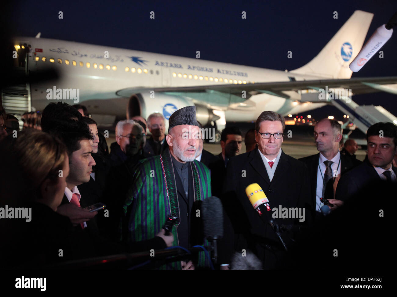 Afghanistans Präsident Hamid Karzai (C) gibt Interviews nach der Begrüßung durch Bundesaußenminister Guido Westerwelle (3-R) nach seiner Ankunft am Flughafen Köln-Bonn in Köln, 2. Dezember 2011. Hamid Karzai hat den Vorsitz der internationalen Afghanistan-Konferenz in Bonn am 5. Dezember 2011. Foto: OLIVER BERG Stockfoto