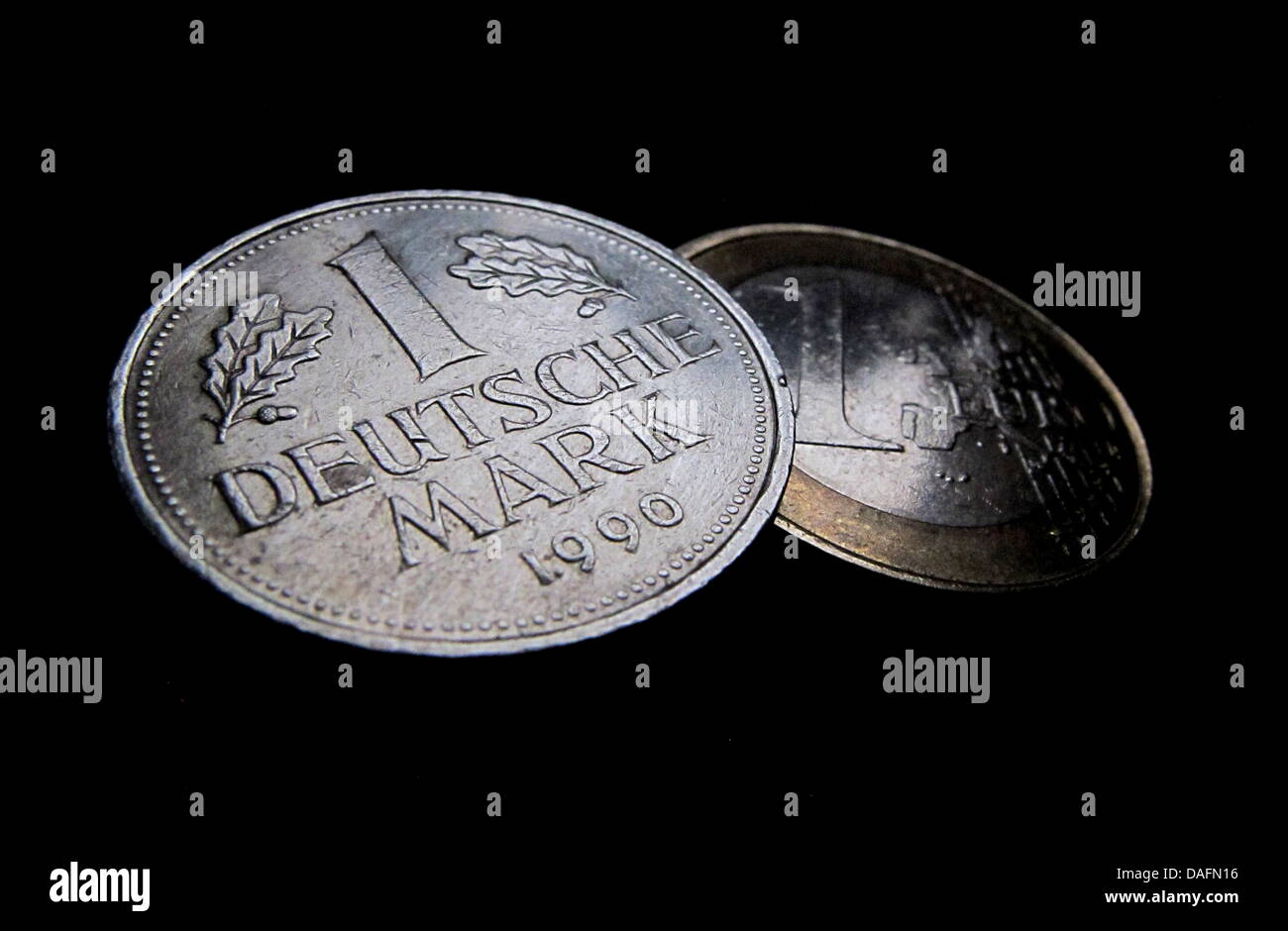 (Dpa Datei) - ein Datei-Bild datiert 17. Dezember 2010 zeigt ein Beispiel für eine Deutsche Mark Münze auf einem ein-Euro-Münze in Kaufbeuren, Deutschland. Auch zehn Jahre nach der Einweihung des Euro ist noch weithin als Leben teurer gemacht haben, aber seine Anhänger halten es weiterhin eine gute Idee sein. Foto: Karl-Josef Hildenbrand Stockfoto