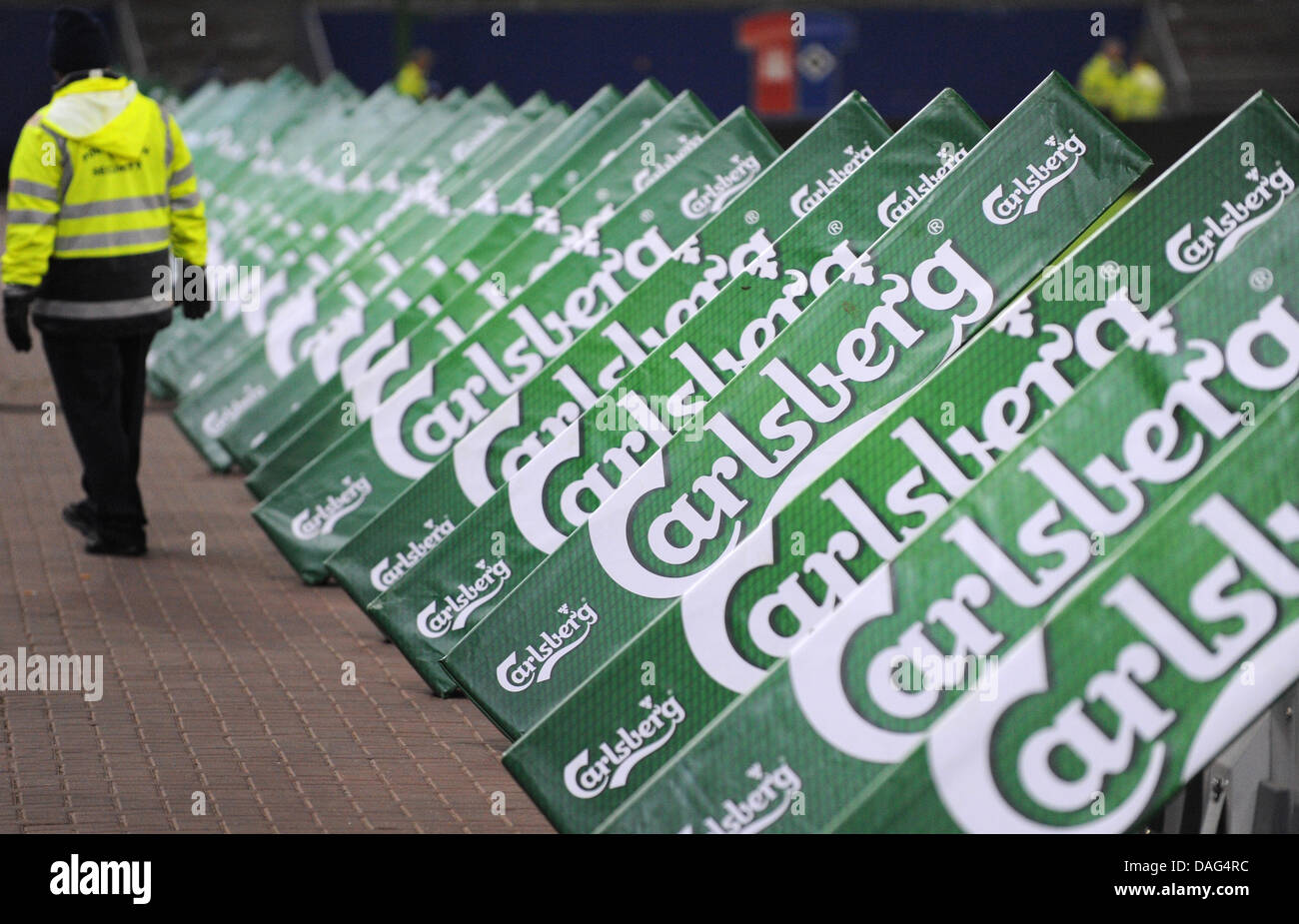(Dpa-Datei) Ein Datei-Bild datiert 22. Oktober 2010 der Steward vorbeigehen Werbetafeln der Carlsberg-Brauerei-Gruppe im Stadion Imtech Arena in Hamburg, Deutschland. Carlsberg-Brauerei-Gruppe berichtet über 18. März 2011, war es auf dem hart umkämpften deutschen Biermarkt mit den Strategien der Kernmarken standhalten, Carlsberg, Holsten, Astra, Stockfoto