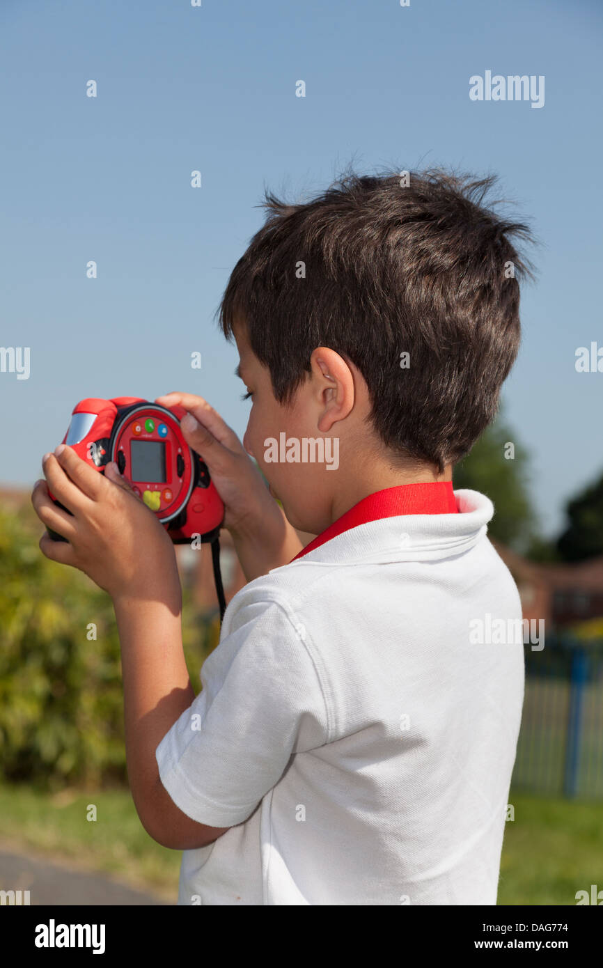 Kind nimmt Fotos mit einer Spielzeugkamera Stockfoto