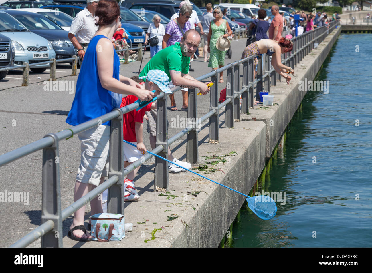 Familiengruppen Verdrehungen auf der Qyay am Mudeford Stockfoto