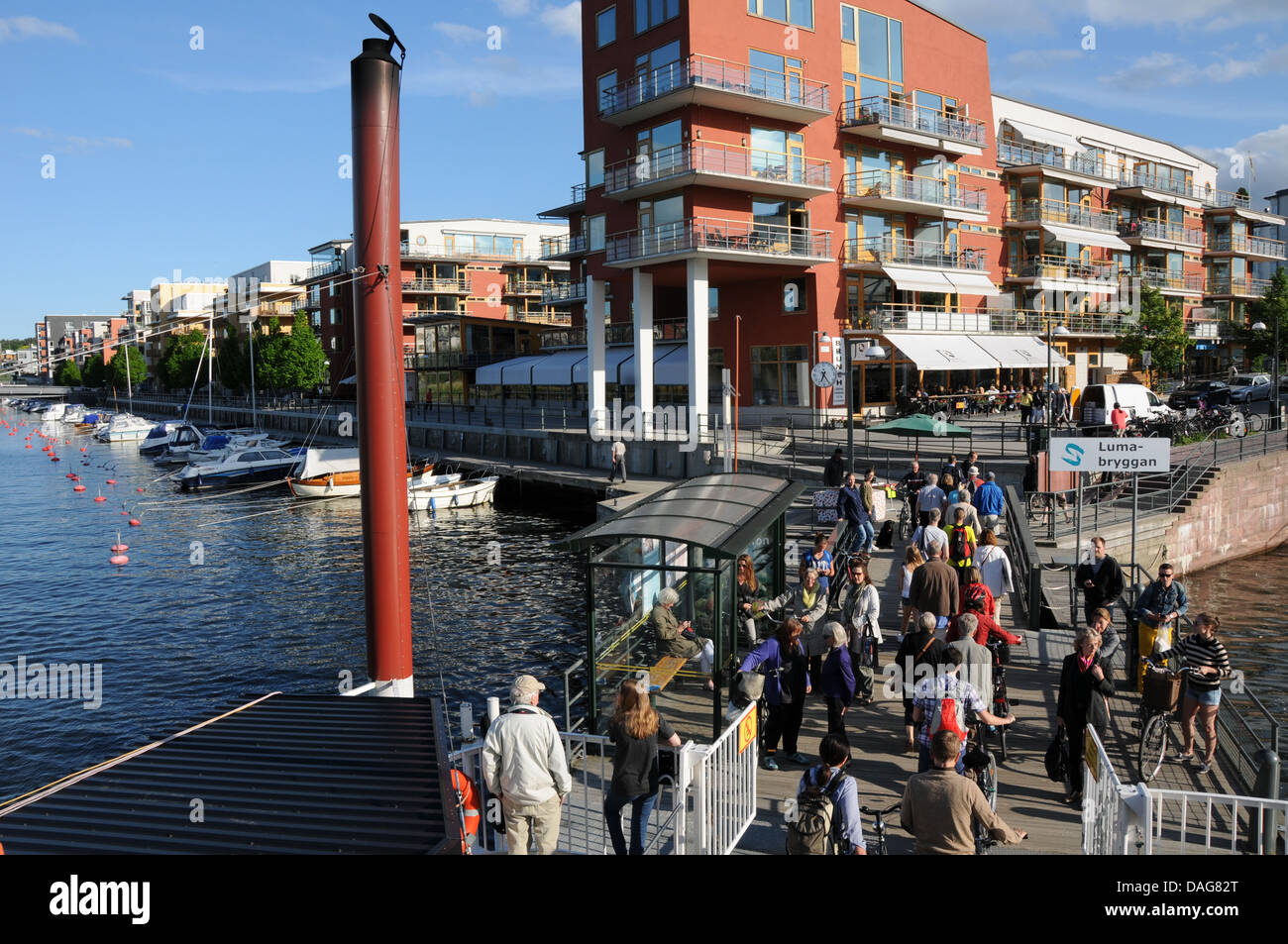 Nachhaltige Stadtentwicklung in Hammarby Sjöstad in Stockholm mit Restaurants am Wasser, Bootsanleger, Wohnungen und Fähre Stockfoto