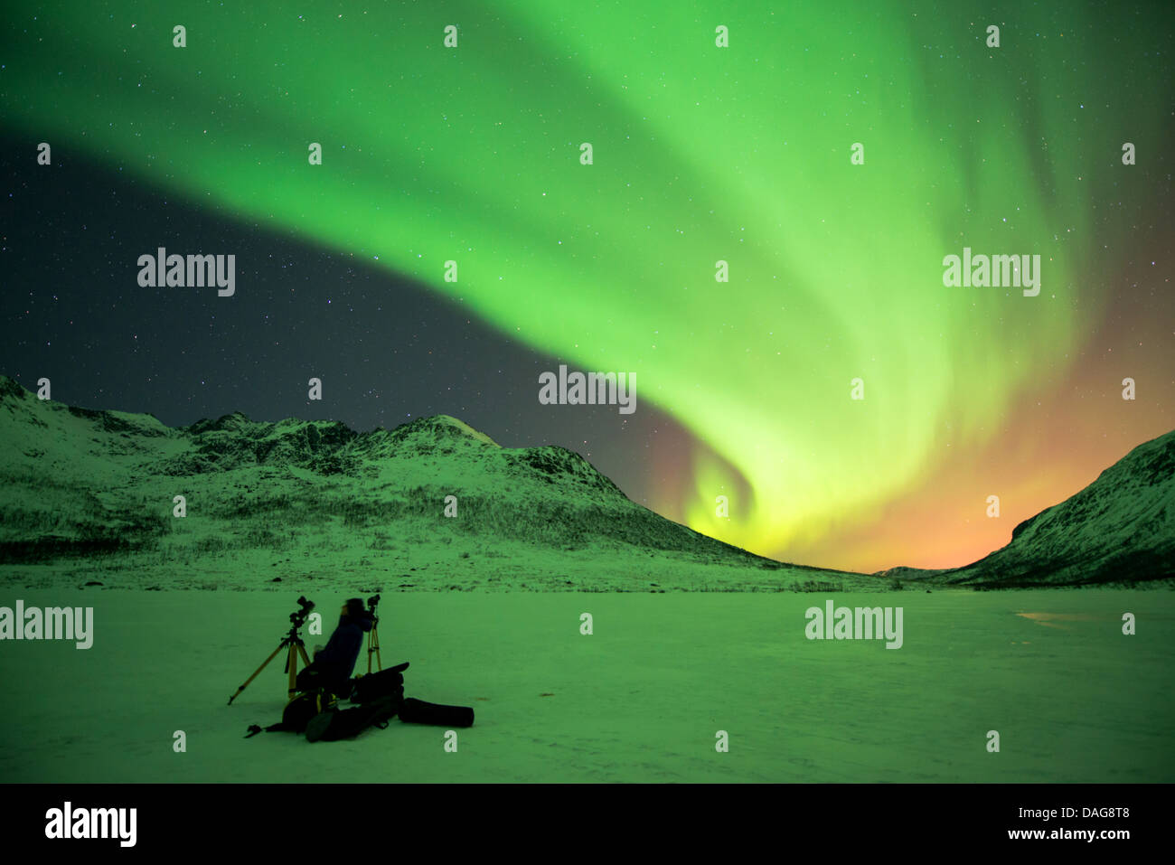 Aurora-Vorhang vor der bestirnte Himmel über tief verschneiten Tal mit ein Naturfotograf Ausrüstung im Schnee, Kattfjordeidet, Kvaloea, Troms, Norwegen Stockfoto