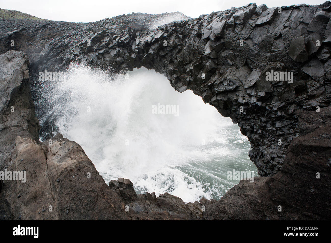 Wellen, die durch schwarzen Bogen von Lava - in der Nähe von Dyrhólaey, Southern Island Stockfoto