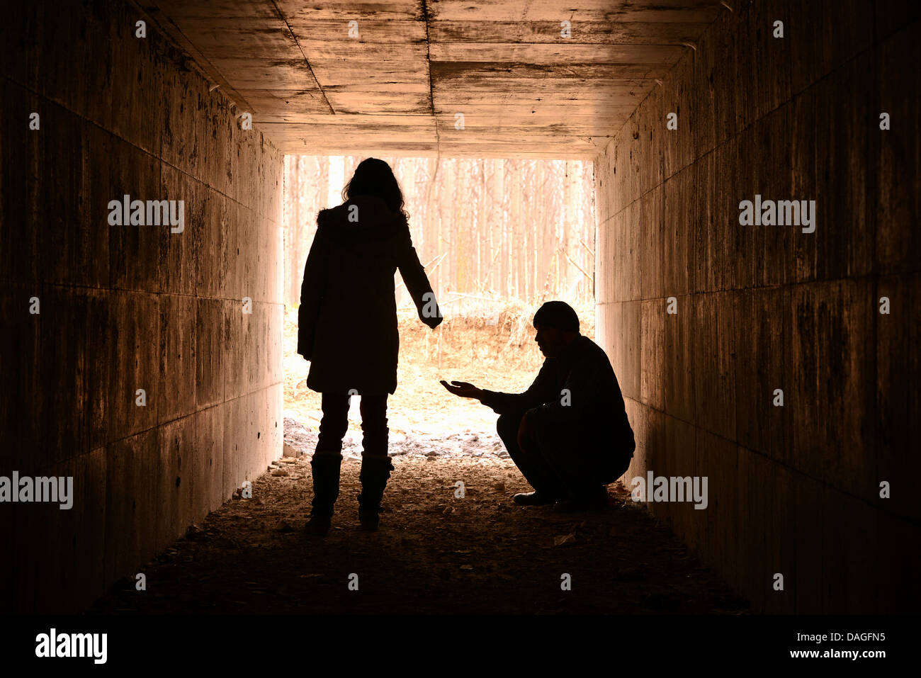 armer Mann und junge Frau silhouette Stockfoto