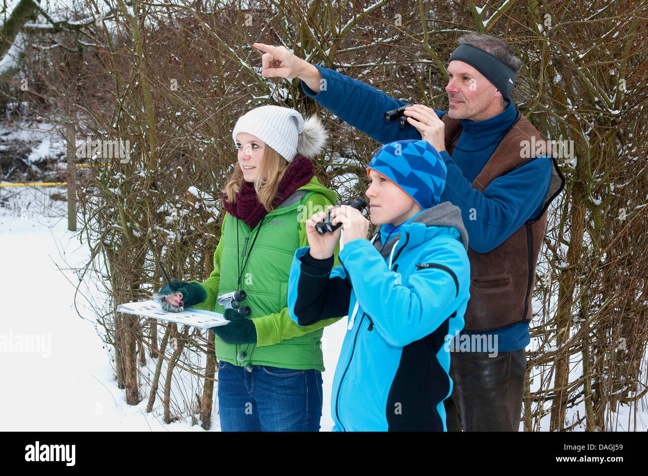 Vogelbeobachtung im Garten im Winter, Familie beobachten Vögel, Deutschland Stockfoto