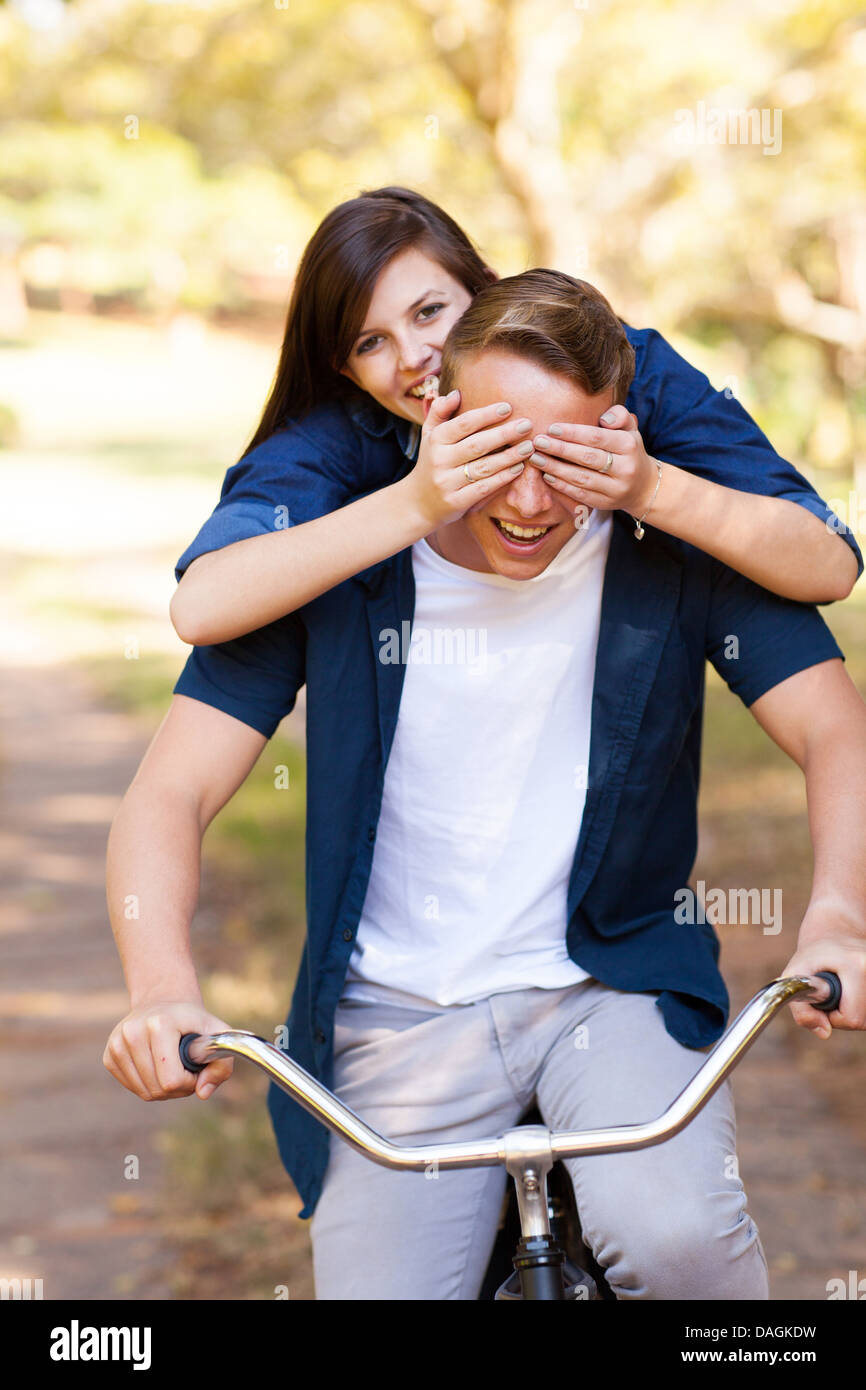 verspielte Teen Mädchen Freundes Augen mit Händen zu bedecken, während der Fahrt ein Fahrrad Stockfoto
