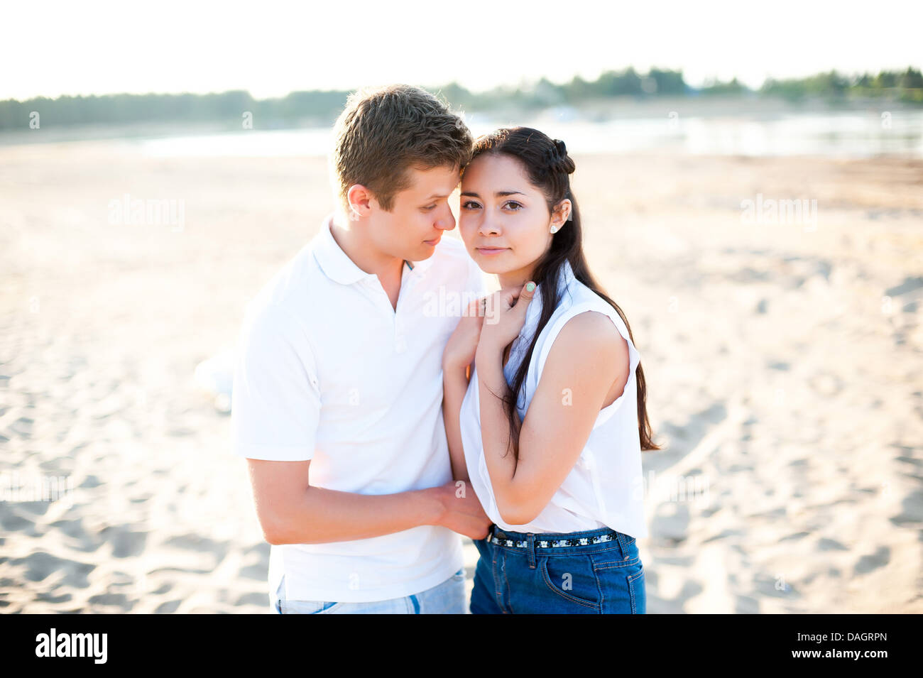 Paar in Liebe Spaziergänge am Ufer des Flusses im Jeans-Shorts und ein weißes Hemd. Stockfoto