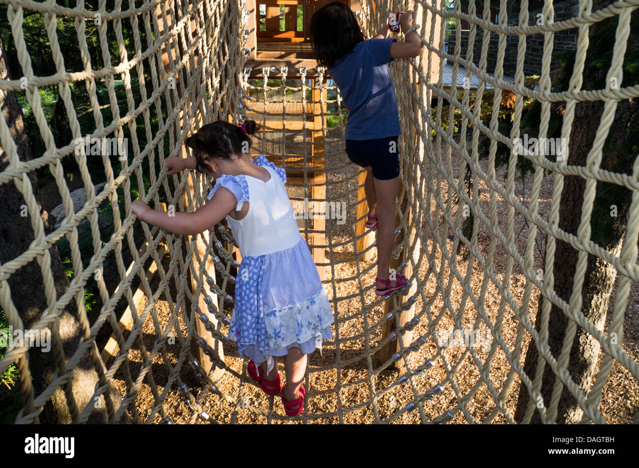 Zwei Mädchen Kreuz eine Hängebrücke der Seile hergestellt. Stockfoto