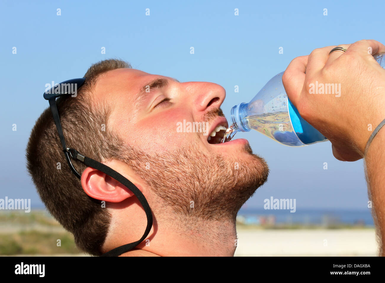 Ein Mann durstig eifrig trinken Wasser aus Kunststoff-Flasche Stockfoto