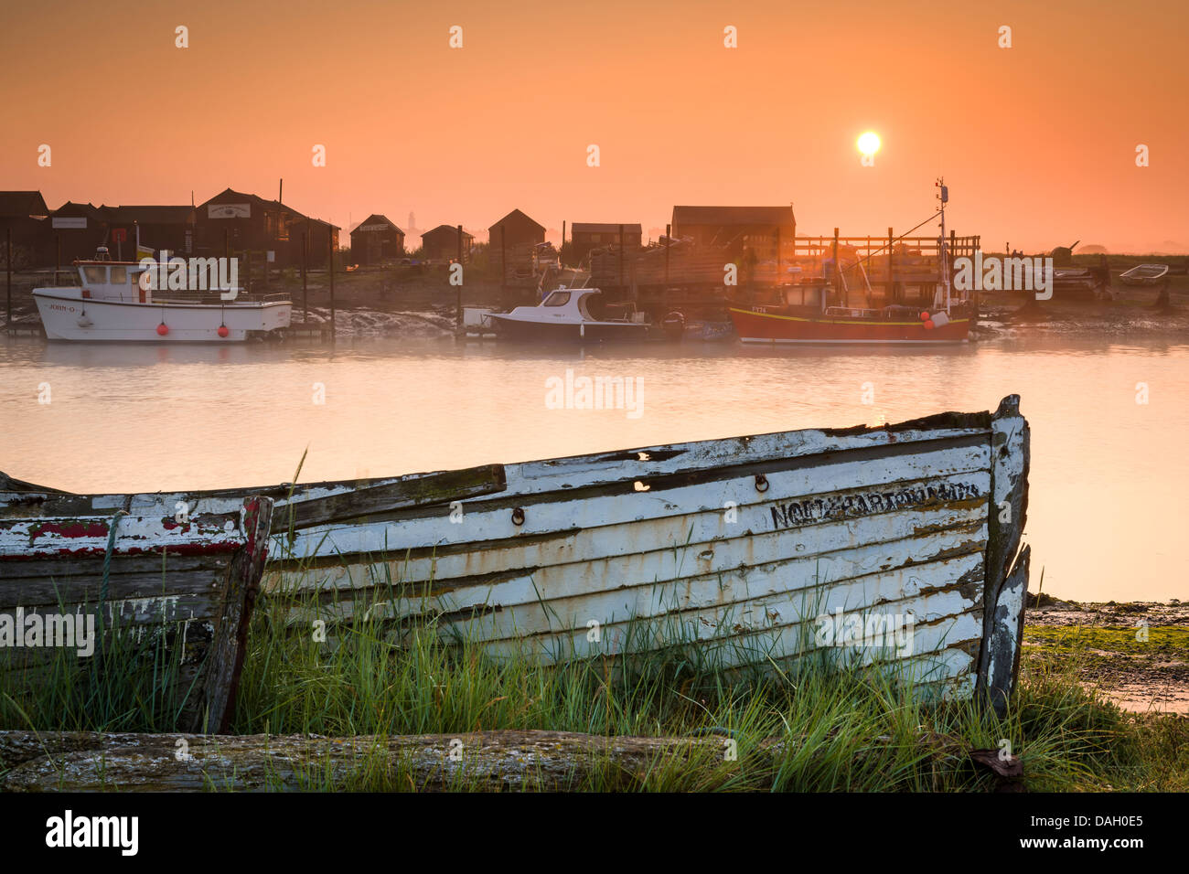 Die Sonne geht über zwei längst vergessene Boote am Ufer der Mündung des Flusses Blyth in Walberswick, Suffolk - England. Stockfoto