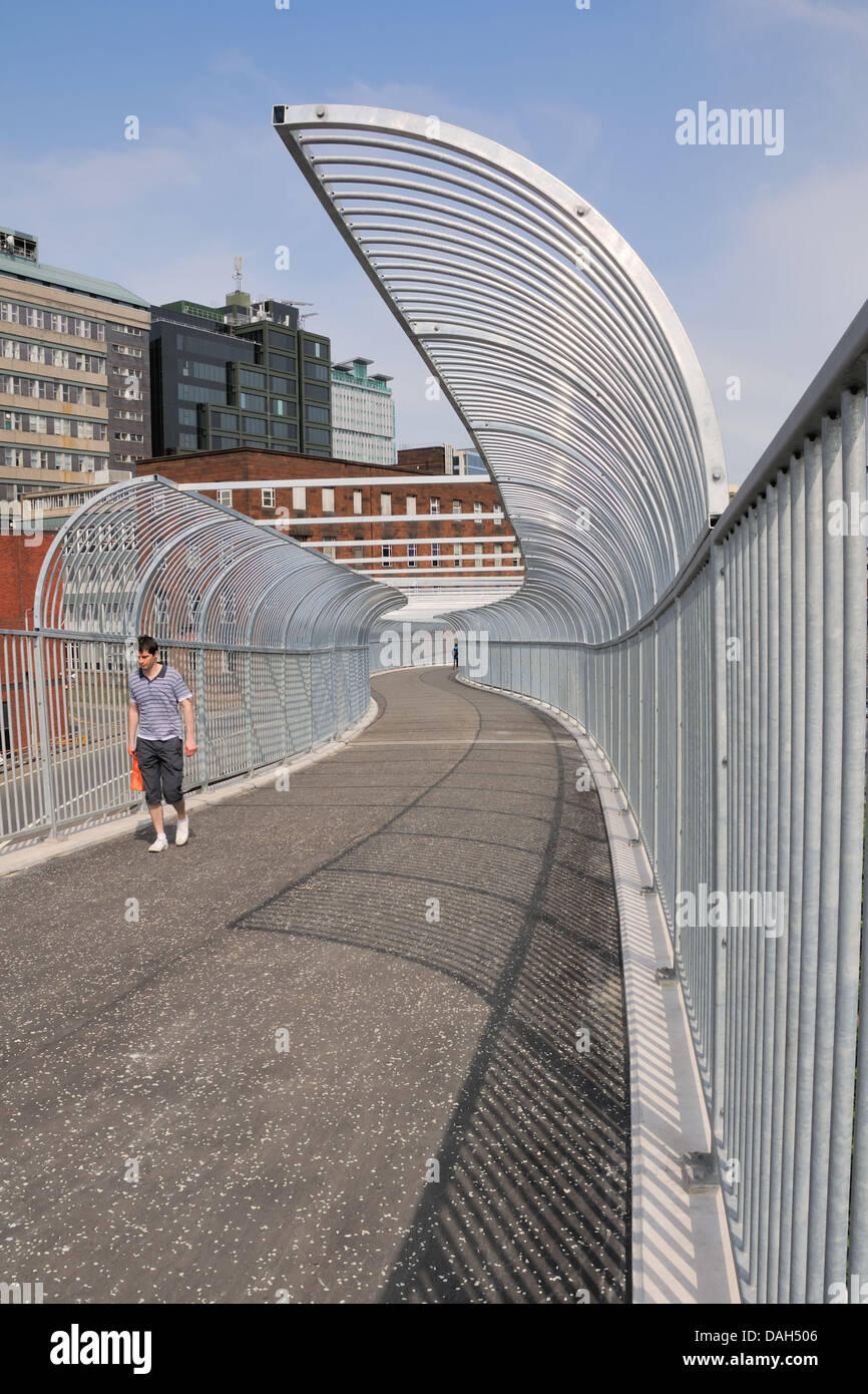Mann Kreuzung Fußgängerbrücke über die Autobahn in Glasgow, Schottland Stockfoto