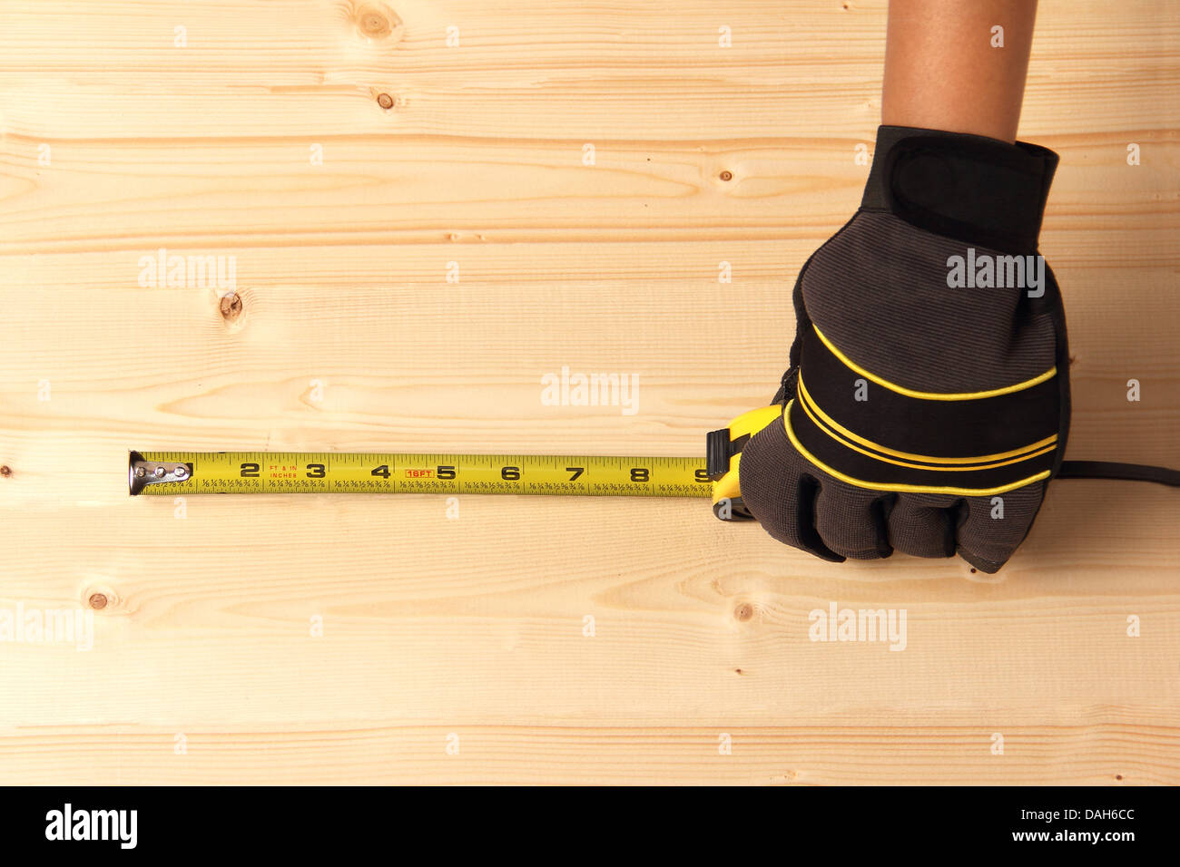 Arbeiter, die Messung auf einem Block aus Holz Stockfoto