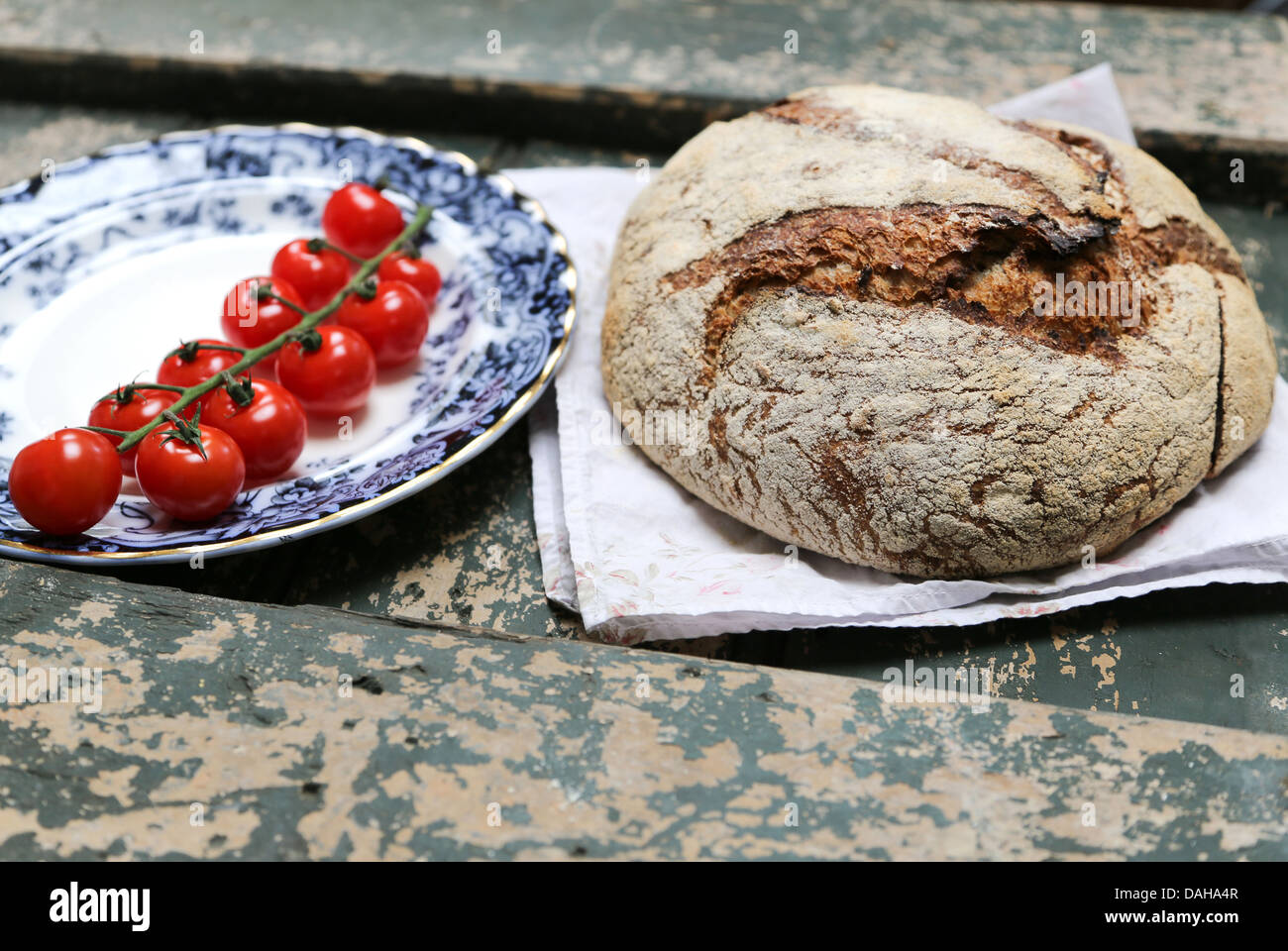 Rustikale Schwarzbrot Brot mit roten Tomaten am Rebstock Stockfoto