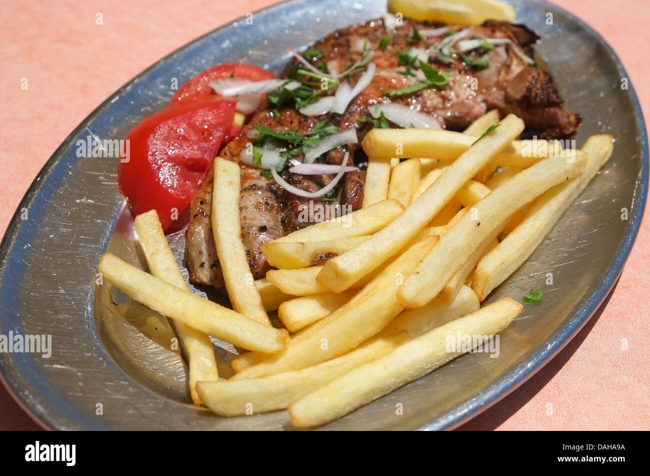 Gegrilltes Schweinekotelett und Pommes frites Essen - Fokus auf Vordergrund Stockfoto