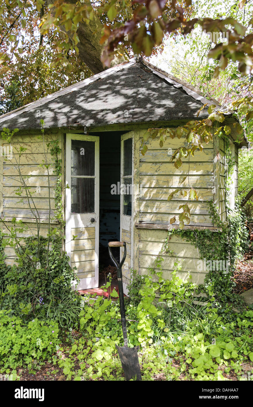 Alten verwitterten Potting Gartenhaus im Schatten der Bäume Stockfoto